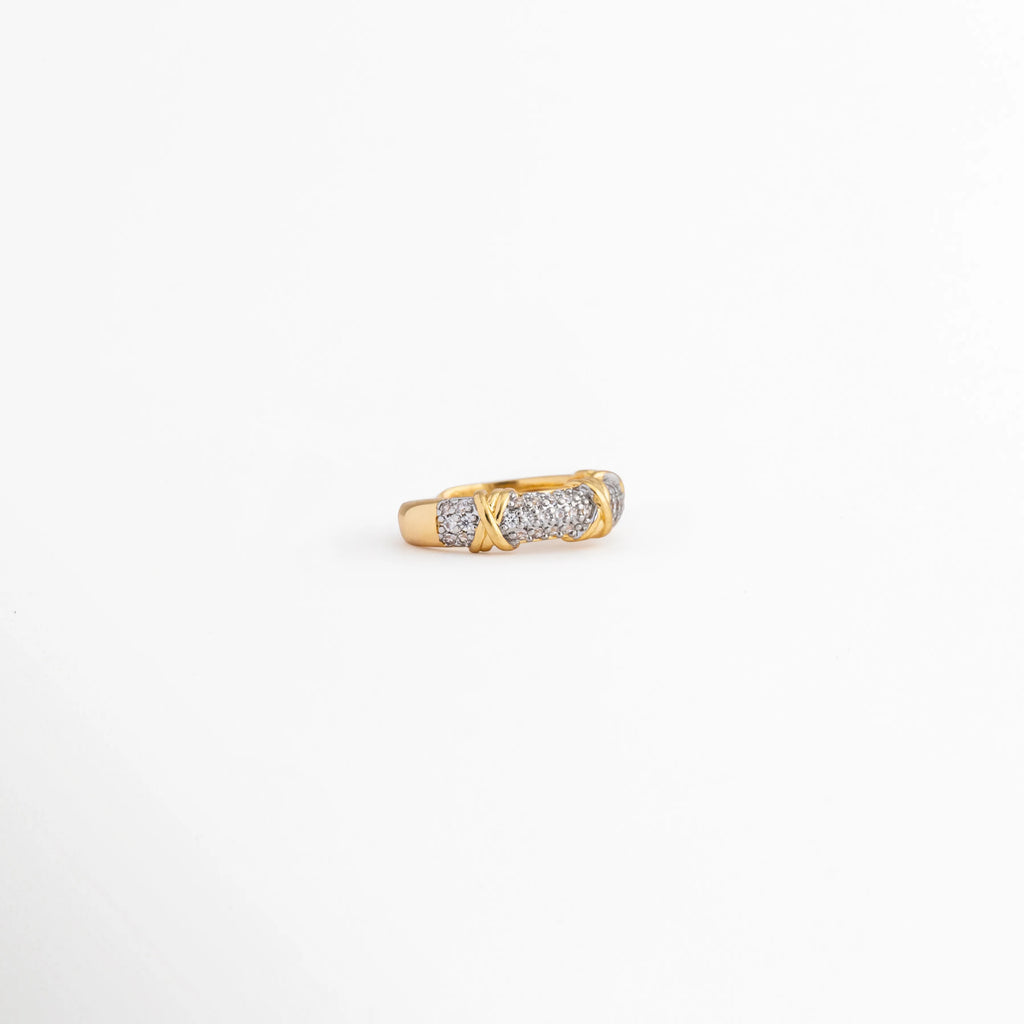 Detalle frontal de anillo Kira con zirconias brillantes y acabado dorado, Vista superior de anillo ajustable con diseño clásico y zirconias, Anillo dorado con línea de zirconias que reflejan la luz elegantemente, Detalle de anillo chapado en oro 18K con incrustaciones de zirconia, Anillo elegante con acabado brillante y piedras de zirconia en primer plano