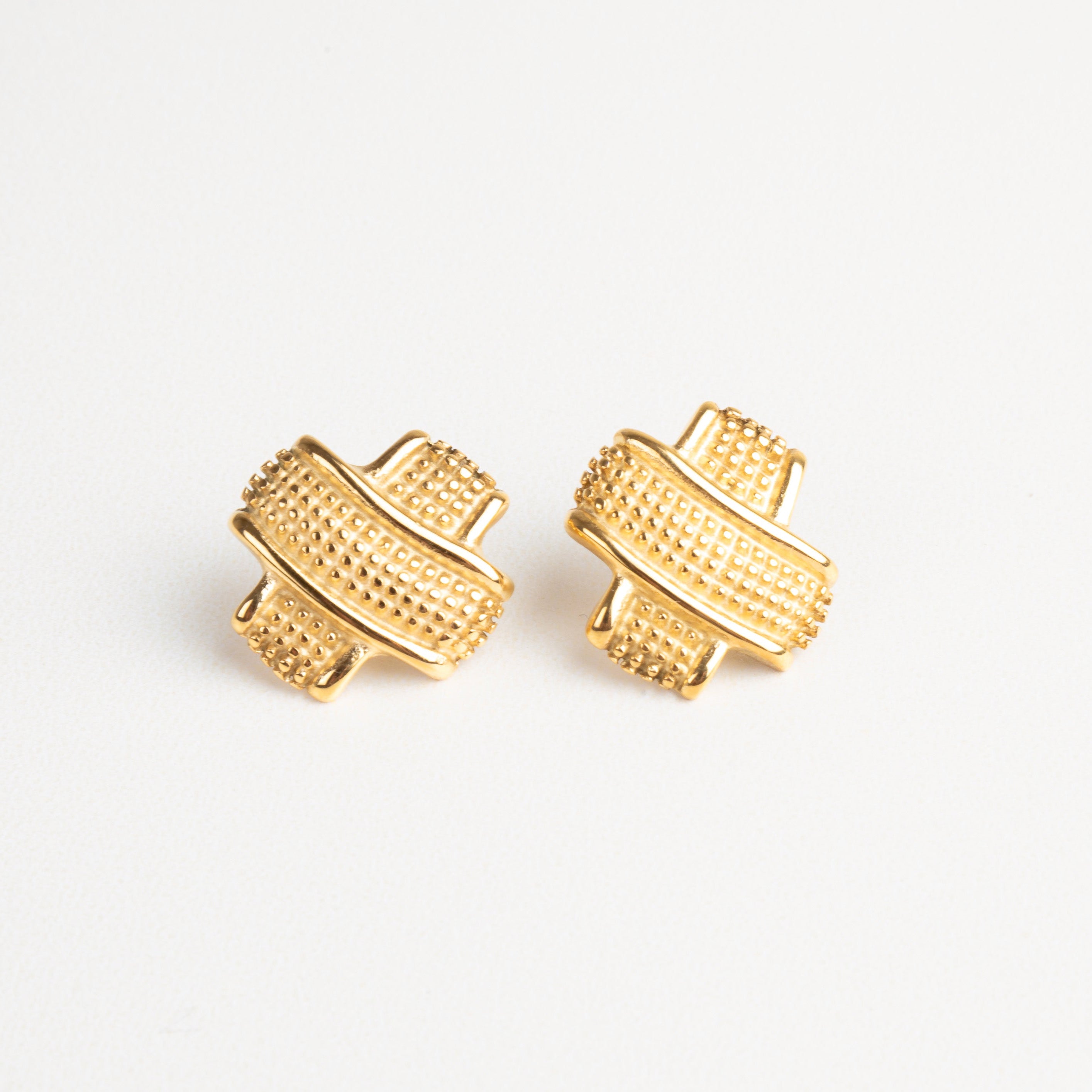 Aretes dorados tipo tacha con textura elegante, ideales para un look moderno y sofisticado