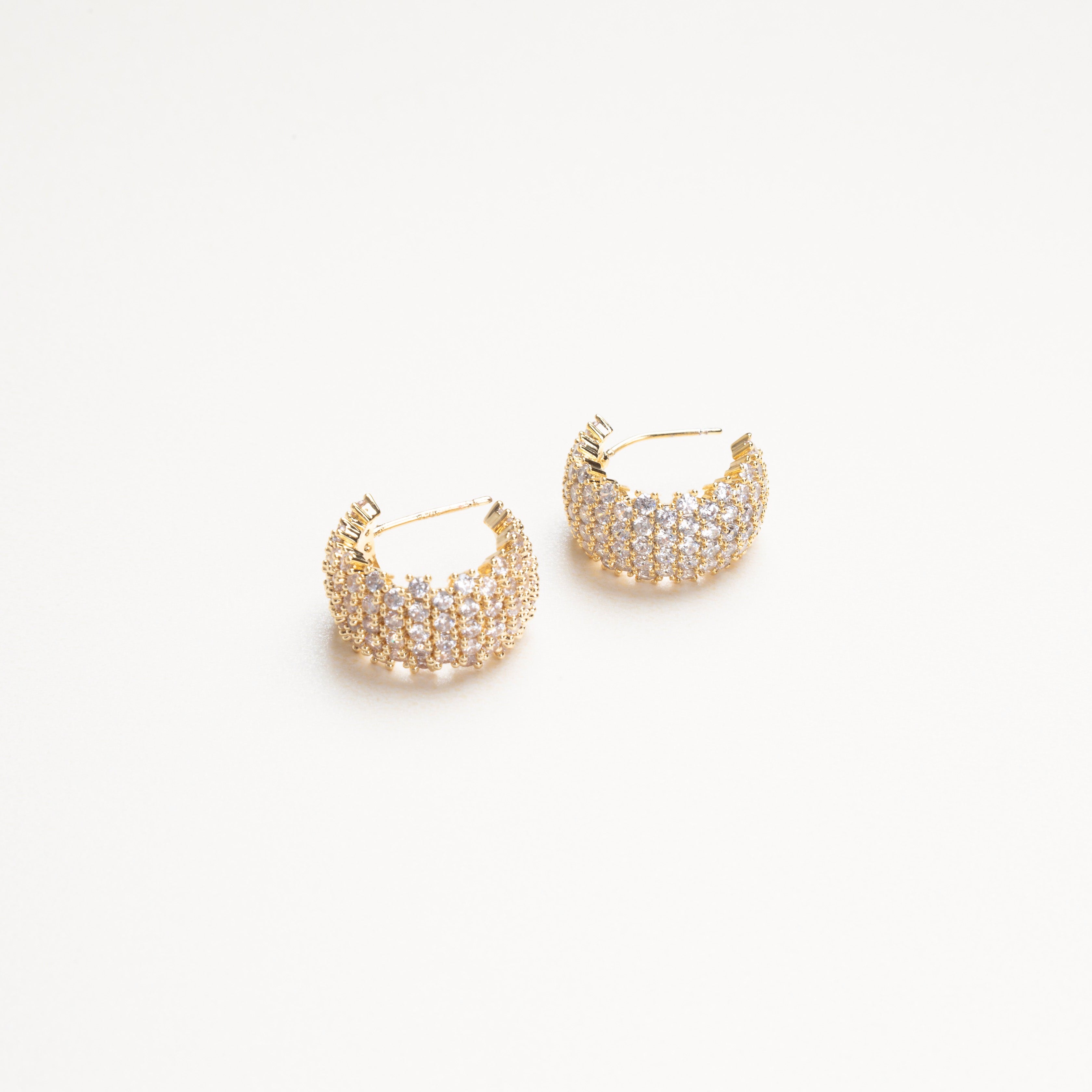 vista de perfil de arracadas doradas con incrustaciones de zirconias, aretes de fiesta, aretes de noche, aretes con pedrería 