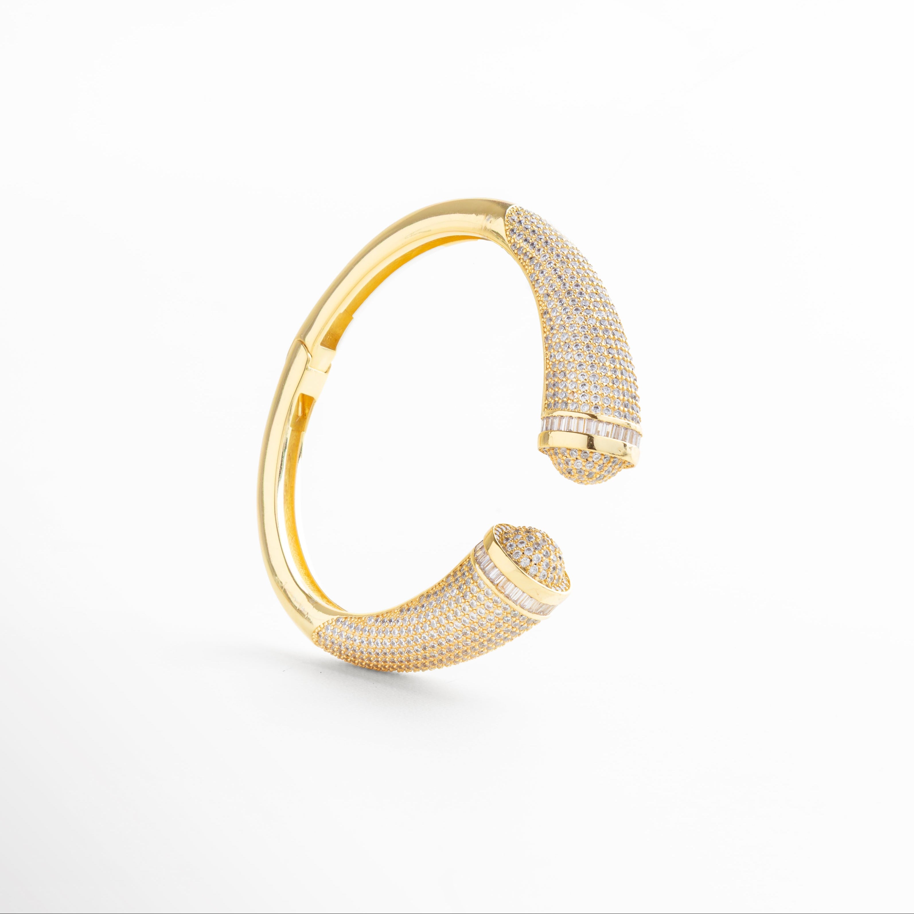 Incrustaciones alineadas en parte superior del brazalete, Brillo sutil de las piedras sobre fondo metálico, Curvatura delicada con zirconias visibles al frente, Transición suave entre metal y piedras, Detalle lateral del diseño envolvente sin cierre
