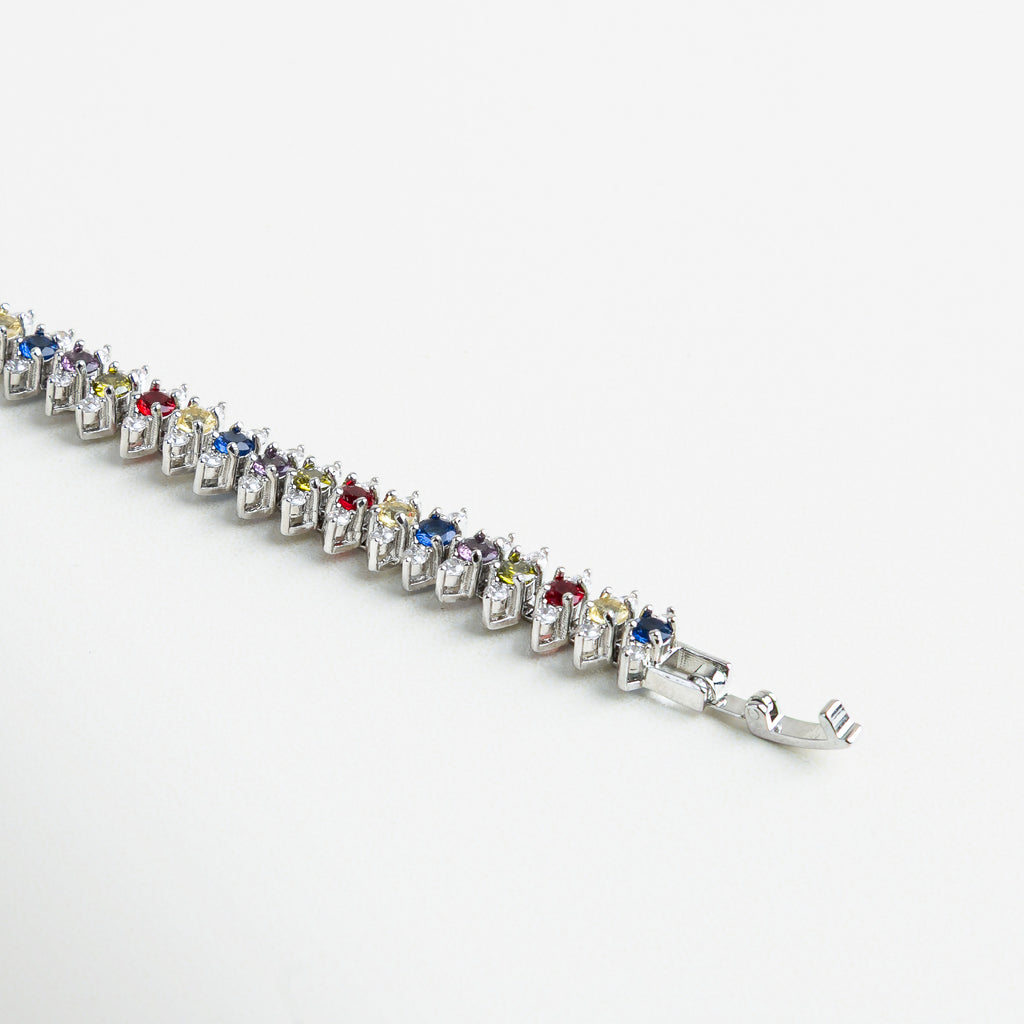 Detalle de circonitas multicolor en pulsera dorada, Zirconias facetadas con acabado brillante en pulsera, Incrustaciones de zirconias coloridas sobre base dorada, Pulsera con piedras multicolores talladas con precisión