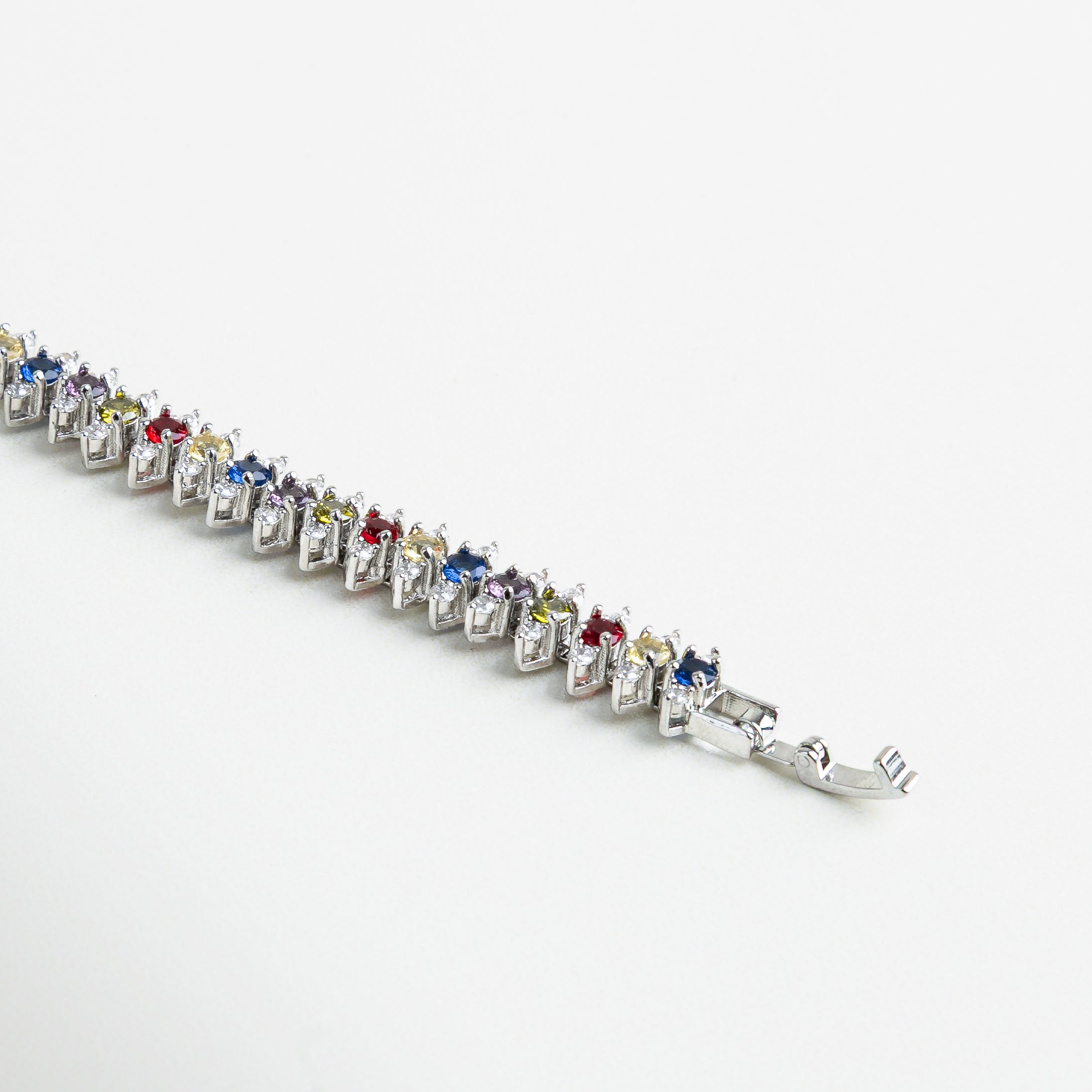 Detalle de circonitas multicolor en pulsera dorada, Zirconias facetadas con acabado brillante en pulsera, Incrustaciones de zirconias coloridas sobre base dorada, Pulsera con piedras multicolores talladas con precisión