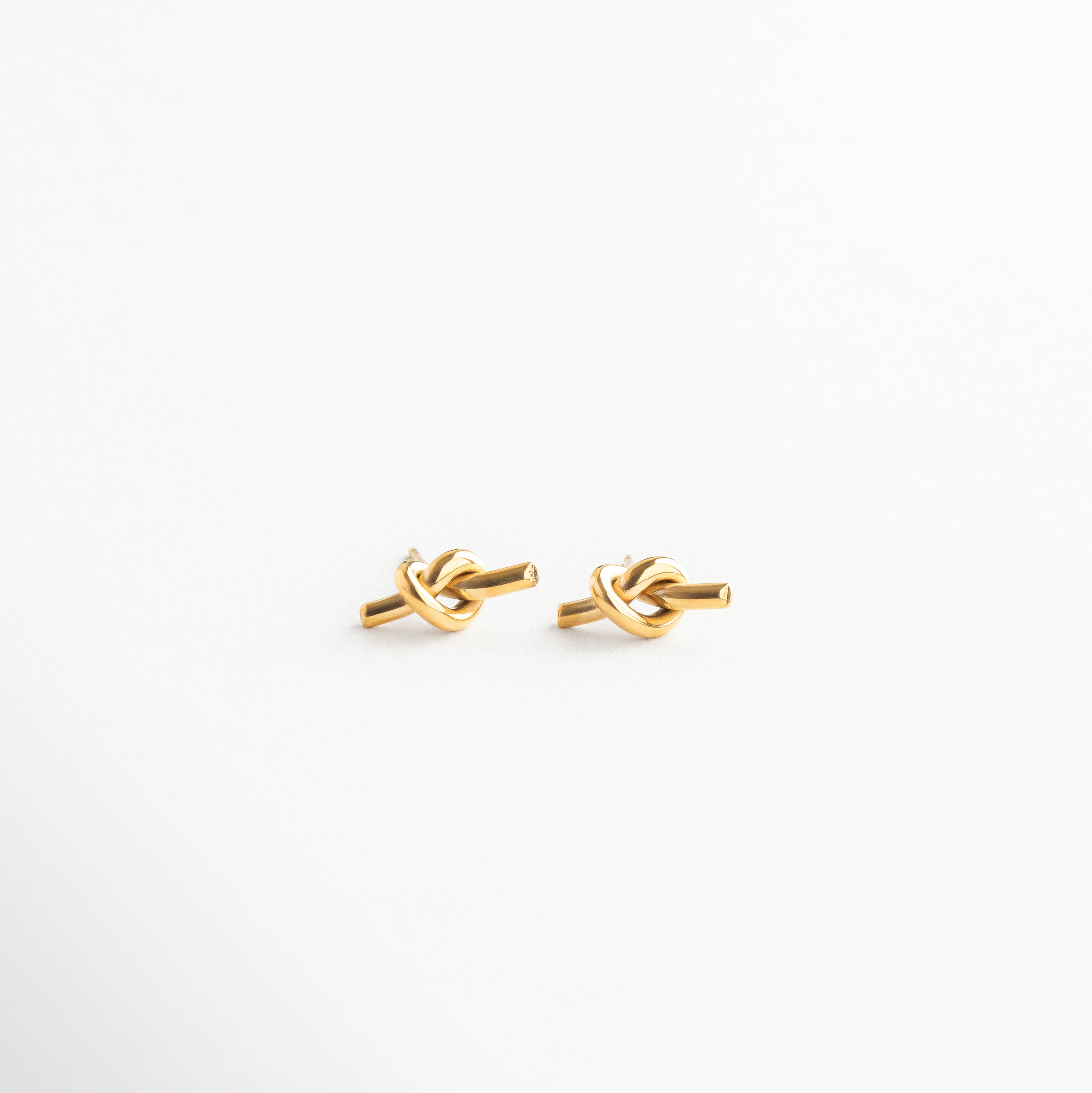 Aretes dorados entrelazados de acero inoxidable, Diseño de nudo con baño de oro 18K, Aretes estilo clásico con toque moderno, Accesorio versátil para looks de día o noche, Par de aretes con forma simbólica de conexión