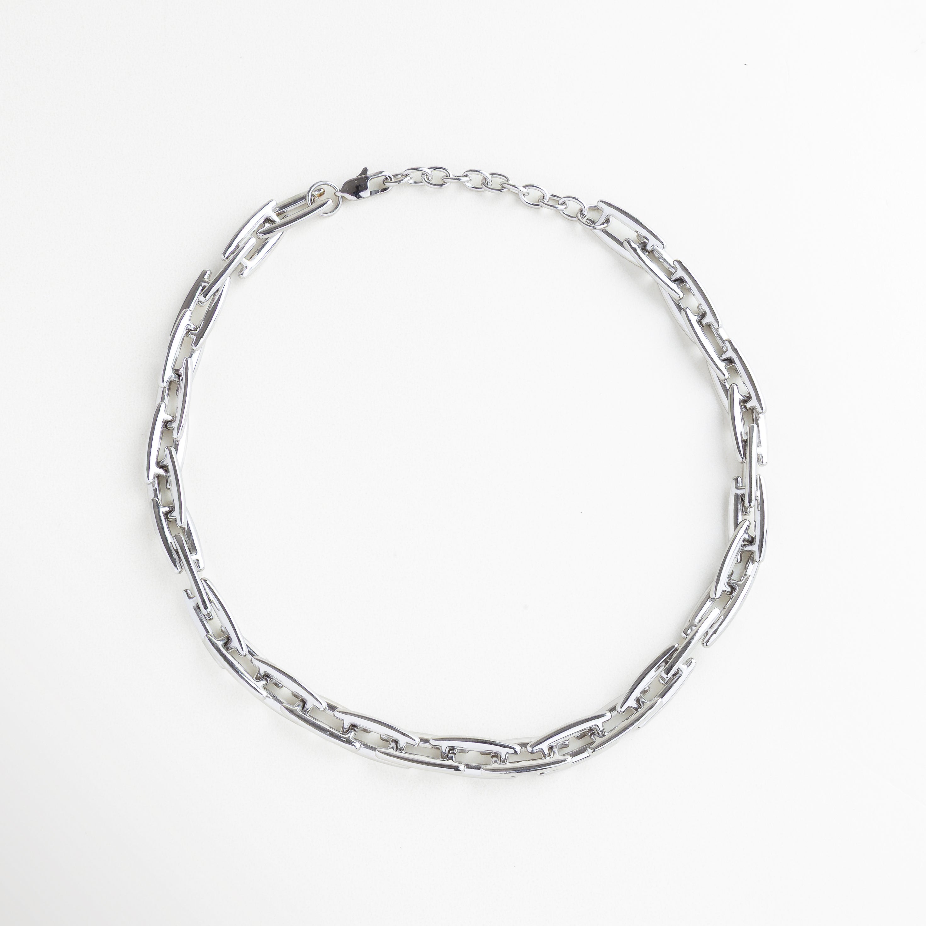 Collar plateado, cadena plateada, Collar Amelia plateado visto de frente, con eslabones anchos y diseño estructurado de acero inoxidable enchapado en plata. Vista frontal del collar de eslabones plateados, con estructura moderna y acabado brillante sobre fondo neutro. Collar en tono plateado con eslabones rectangulares interconectados, estilo fuerte y elegante Primer plano frontal del Collar Amelia, destacando su silueta robusta y diseño contemporáneoCollar plateado de acero inoxidable co