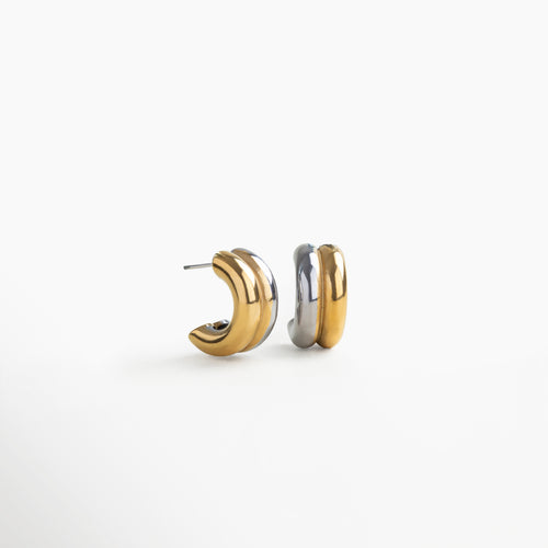 Aretes tipo arracada bitono dorado y plateado con zirconia, vista frontal detallada, Vista frontal de hoops bicolor en acero inoxidable con acabado brillante y piedra central, Primer plano de arracadas doradas y plateadas con incrustación de zirconia, estilo moderno, Fotografía frontal de aretes circulares bitono con diseño contemporáneo y toque brillante., Aretes de acero inoxidable con mezcla de tonos oro y plata, vista frontal con zirconia.