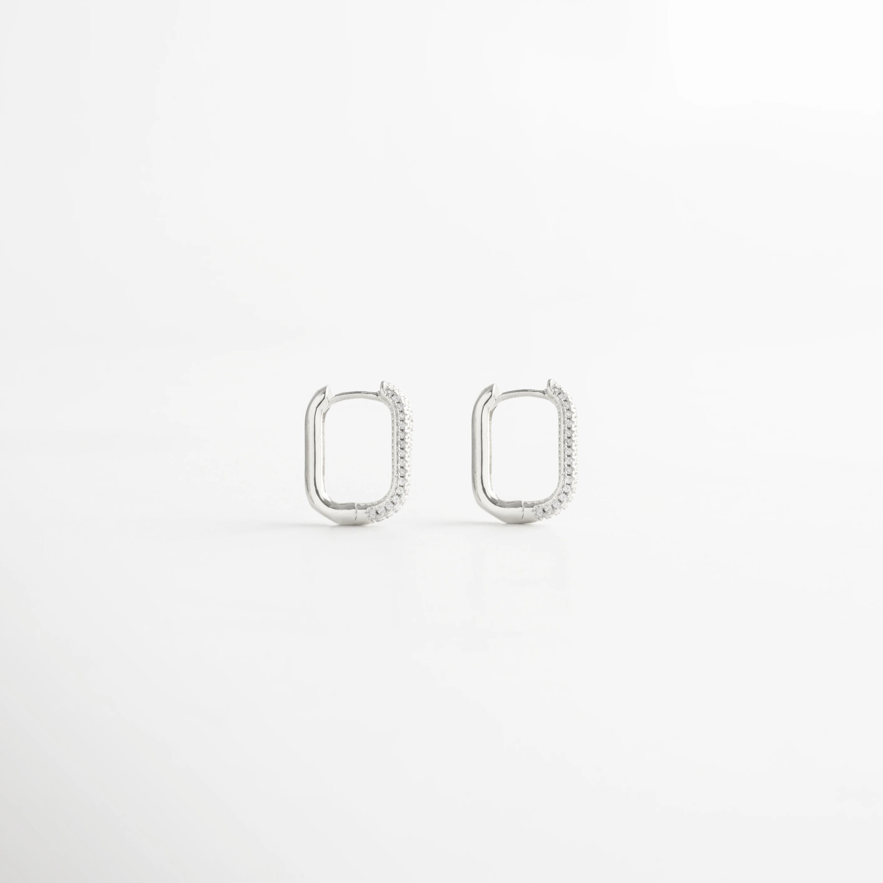 Aretes rectangulares pequeños en tono plateado con detalles brillantes, Arracadas plateadas modernas con incrustaciones de zirconias.