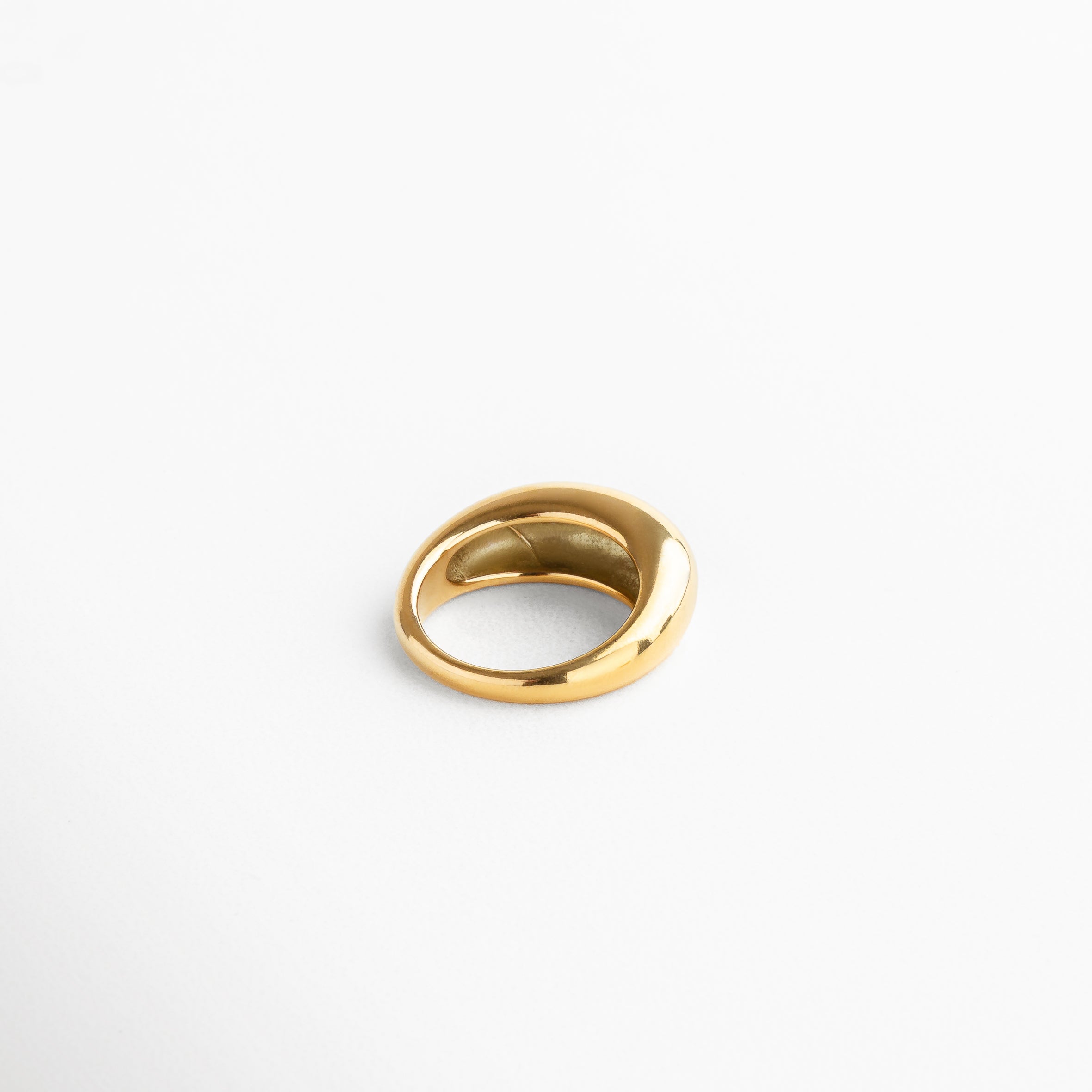 Vista superior del anillo Katerina Golden, mostrando la parte más alta de 7 mm y su forma contemporánea. Anillo Katerina Golden capturado desde arriba, resaltando su volumen y superficie dorada pulida. Toma cenital del anillo en acero inoxidable con chapa de oro, ideal para lucir en combinaciones de joyería. Anillo dorado Katerina Golden desde vista superior, destacando su diseño bold y elegante.Perspectiva superior del anillo Katerina, con acabado en oro de 18K y líneas curvas sofisticadas