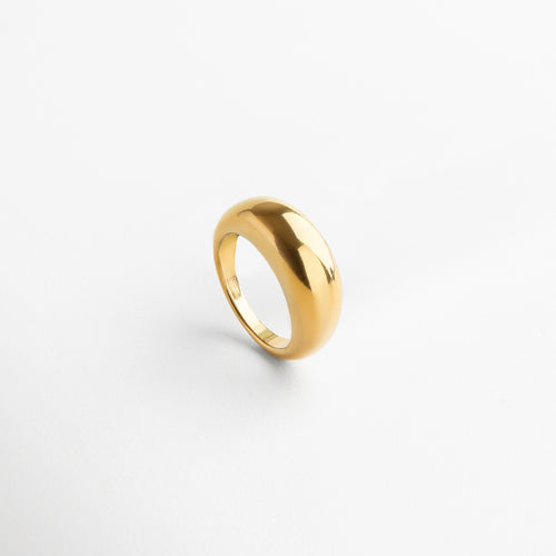 Anillo Katerina Golden visto desde el frente, mostrando su diseño voluminoso y elegante en acero inoxidable con chapa de oro de 18K.Vista frontal del anillo Katerina Golden, con acabado brillante y silueta moderna que destaca por su forma audaz.
Anillo dorado de acero inoxidable desde el ángulo frontal, resaltando su grosor de 5 mm y estilo statement.Diseño moderno del anillo Katerina Golden, con un acabado dorado pulido y estructura sólida visto desde el frente. Primer plano del anillo Ka