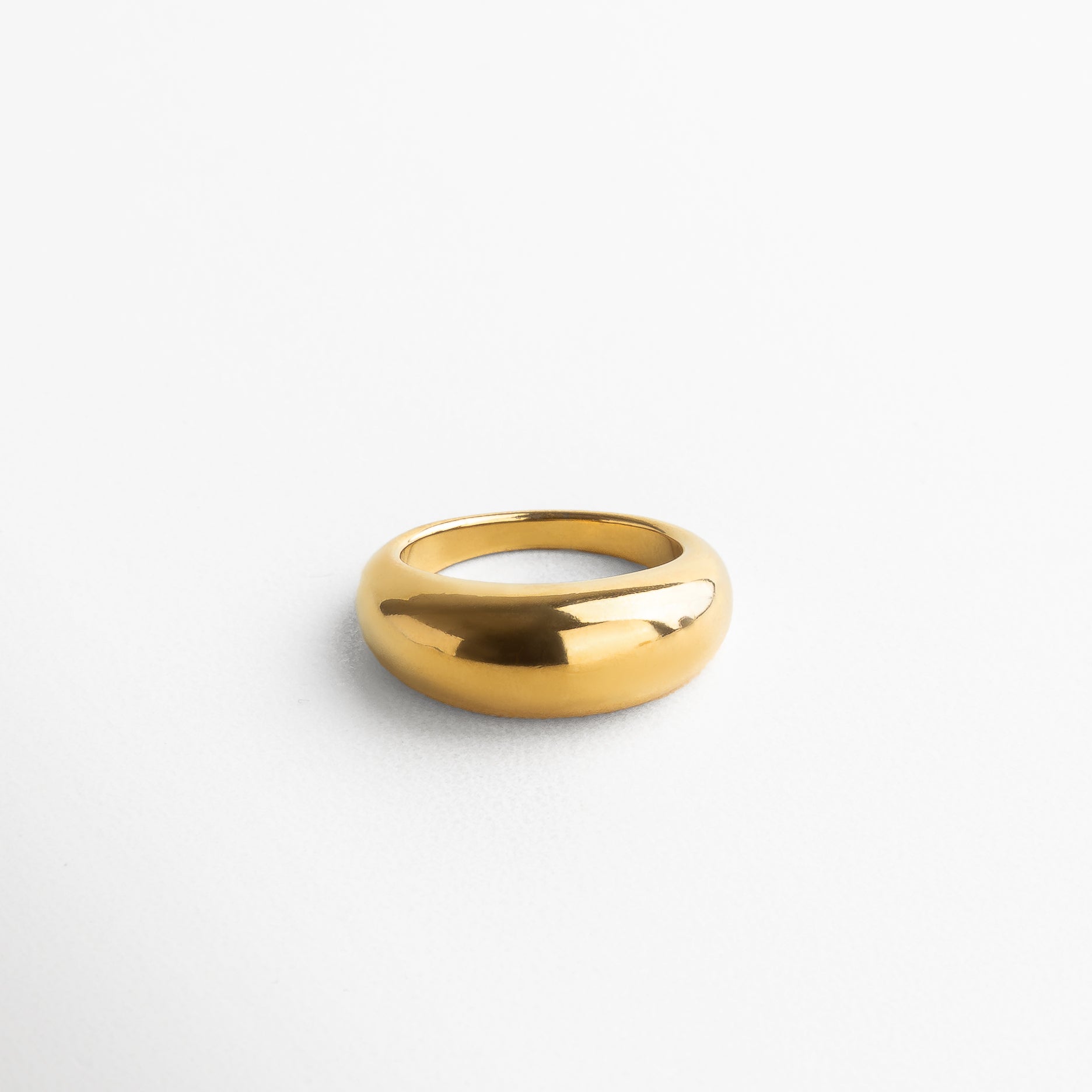 Anillo Katerina Golden visto de perfil, mostrando su altura de 7 mm y estructura robusta en acero inoxidable dorado. Vista lateral del anillo statement Katerina, resaltando su silueta original y elegante. Anillo dorado de acero inoxidable en vista lateral, ideal para combinar con otros accesorios modernos. Detalle lateral del anillo Katerina, con forma voluminosa y acabado en chapa de oro 18K. Perfil del anillo Katerina Golden, mostrando su diseño moderno y curvatura distintiva.