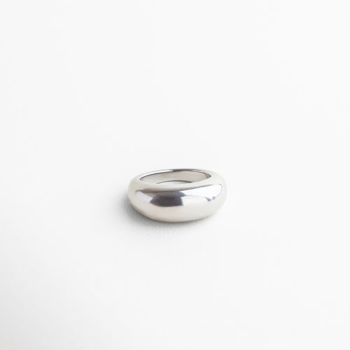 Vista superior del anillo Katerina en acabado plateado, mostrando su parte más alta de 7 mm y superficie lisa. Anillo plateado Katerina visto desde arriba, con diseño elegante en acero inoxidable brillante. Toma cenital del anillo statement Katerina, resaltando su volumen y acabado metálico pulido. Anillo Katerina plateado desde vista superior, destacando su estructura bold y líneas limpias. Perspectiva superior del anillo Katerina, con acabado en acero inoxidable y diseño llamativo.