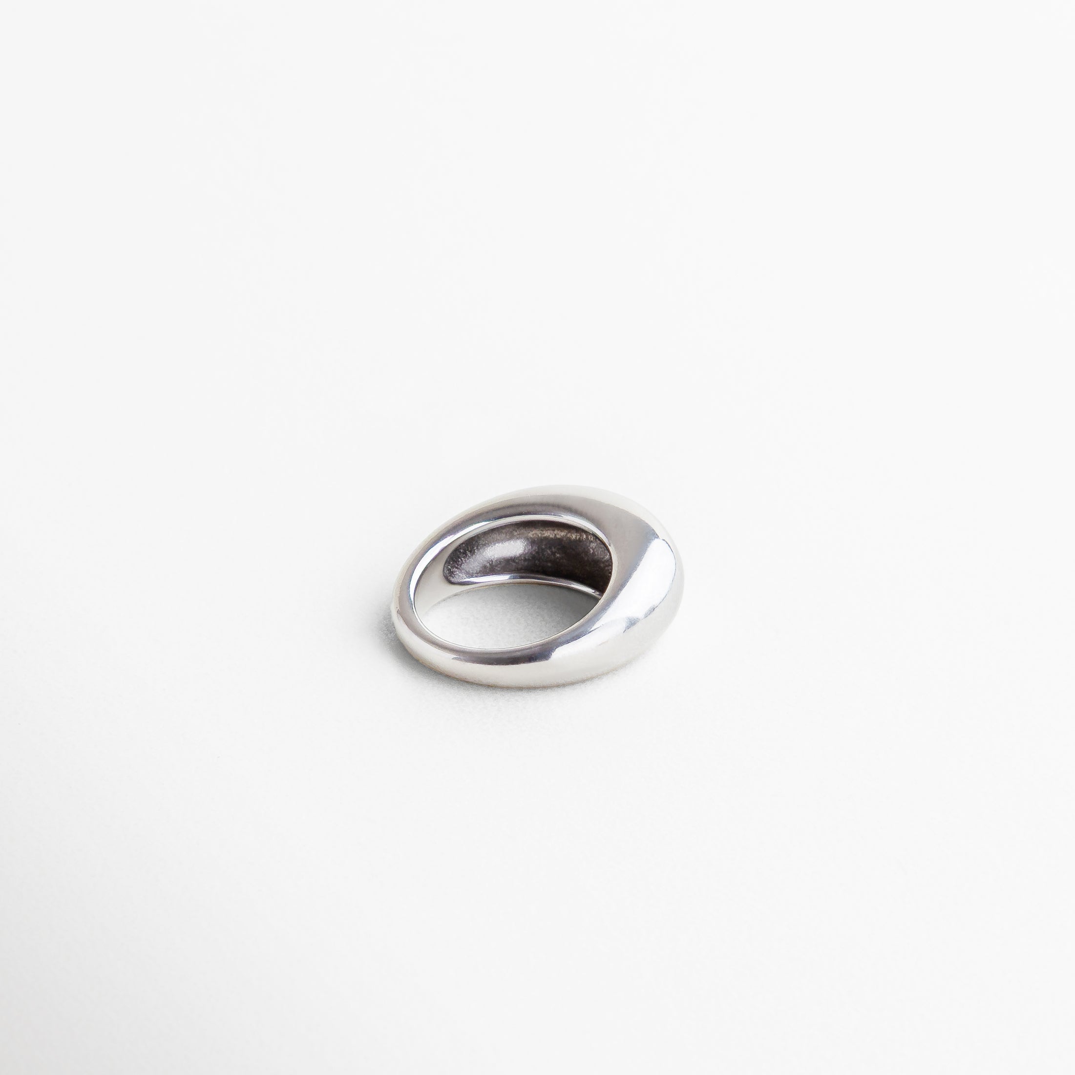Anillo Katerina plateado visto de perfil, mostrando su silueta moderna y altura de 7 mm en acero pulido. Vista lateral del anillo Katerina en tono plateado, resaltando su curvatura elegante y diseño audaz. Anillo en acero inoxidable plateado desde el lado, con estilo minimalista pero impactante.Detalle lateral del anillo Katerina plateado, ideal para combinar con looks modernos o accesorios múltiples. Perfil del anillo Katerina en acabado metálico brillante, con diseño original y estructura 