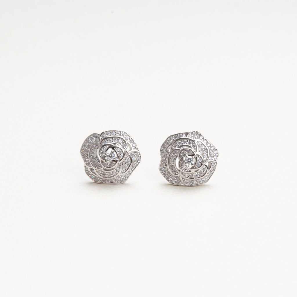 vista frontal de aretes pequeños y sofisticados en forma de flor cn incrustaciones de zirconias