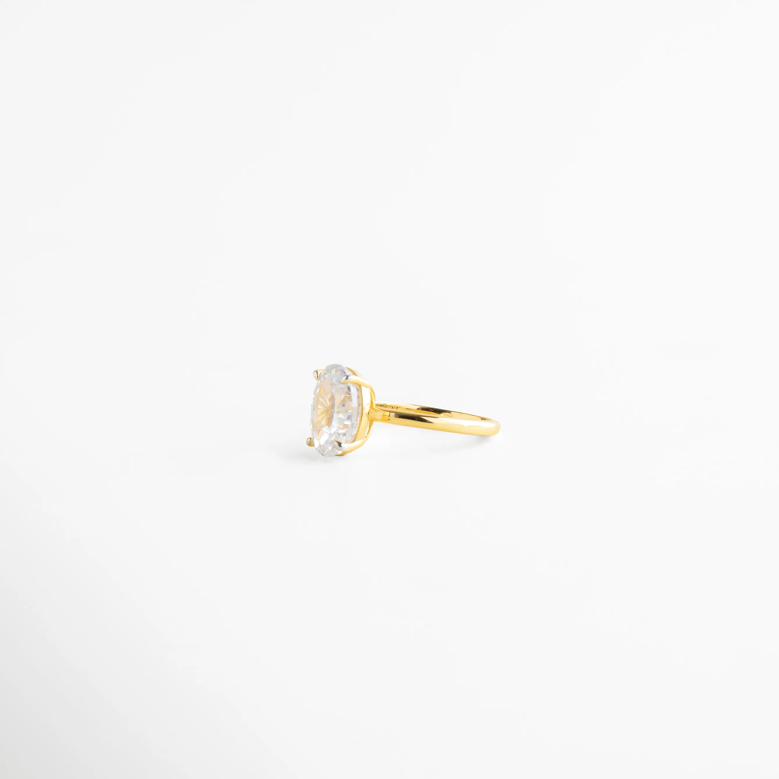 anillo dorado perfil delgado y elegante, anillo con piedra oval montura delicada, anillo fino dorado vista costado, joyería elegante anillo clásico, anillo dorado diseño limpio, anillo femenino sofisticado 