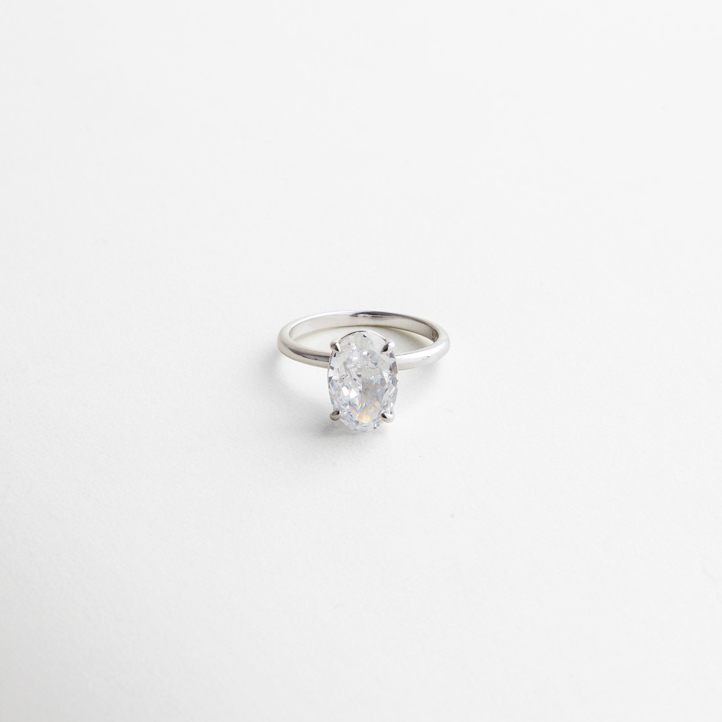 piedra ovalada facetada que refleja la luz, engaste clásico y seguro, brillo intenso y limpio, acabado pulido en plata ley 925, diseño que realza la forma de la gema