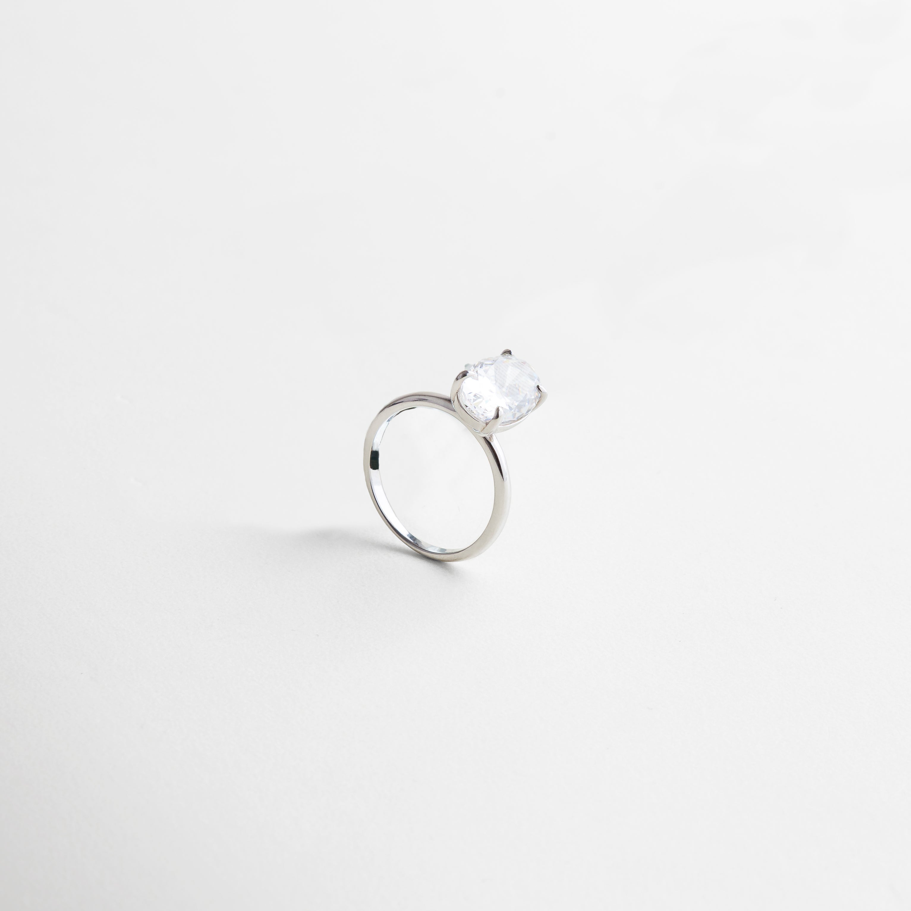 perfil lateral mostrando altura y curvatura de la piedra, engaste elevado para protagonismo, aro liso y refinado, proporción armoniosa entre piedra y estructura, detalles finos de joyería