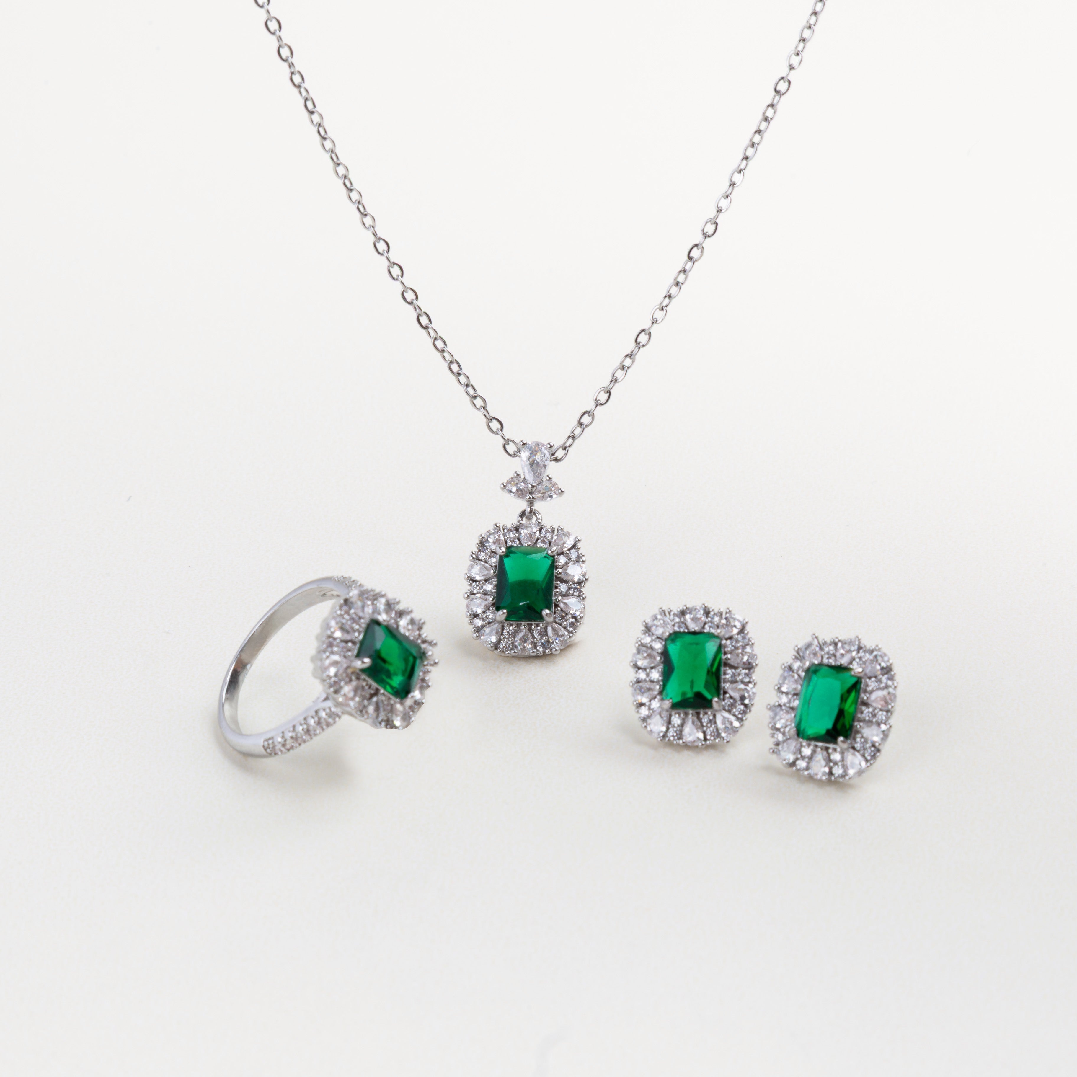 set de joyería plateada con piedra verde, conjunto collar, aretes y anillo esmeralda, joyería elegante con anillo y piedra verde, accesorios completos para mujer, set de joyas con cristales verdes