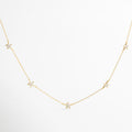Collar dorado con charms de estrellas pavé, diseño delicado y luminoso, joyería inspirada en el brillo del cosmos, accesorio femenino ideal para looks románticos y modernos