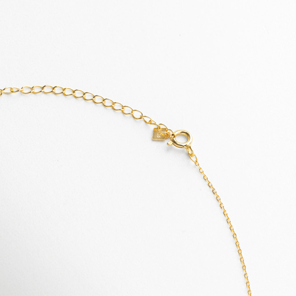 Broche reaso y discreto en collar dorado con charms de estrellas, diseño cómodo y funcional que complementa su estilo delicado
