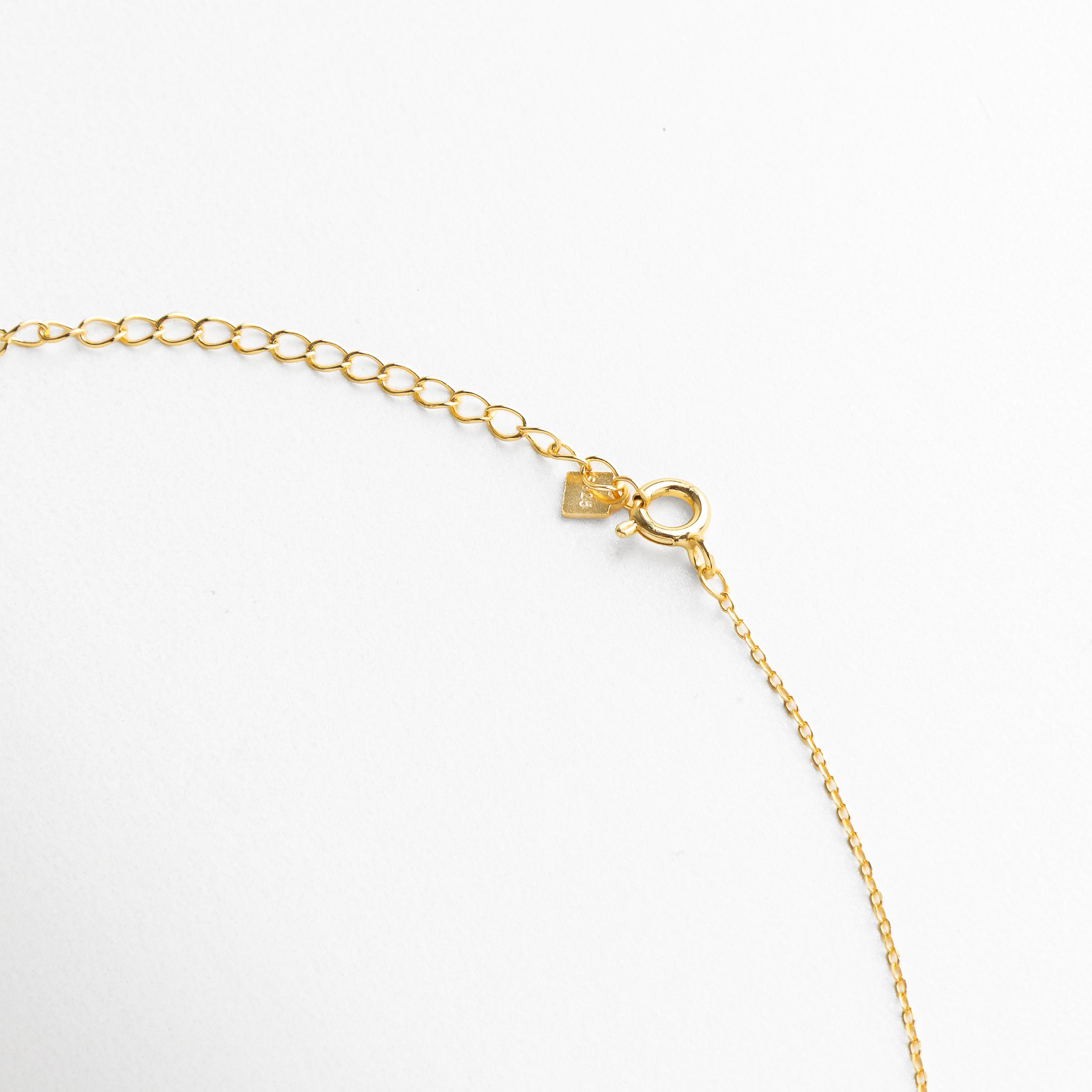 Broche reaso y discreto en collar dorado con charms de estrellas, diseño cómodo y funcional que complementa su estilo delicado