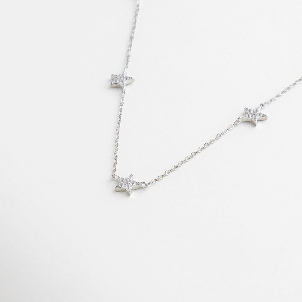 charms de estrellas pavé con zirconias brillantes, textura de la cadena delgada y dijes estrellados, vista cercana del engarce de zirconias en forma de estrella, detalle brillante de estrellas miniatura con acabado pulido, incrustaciones de zirconias sobre estrellas chapadas en plata