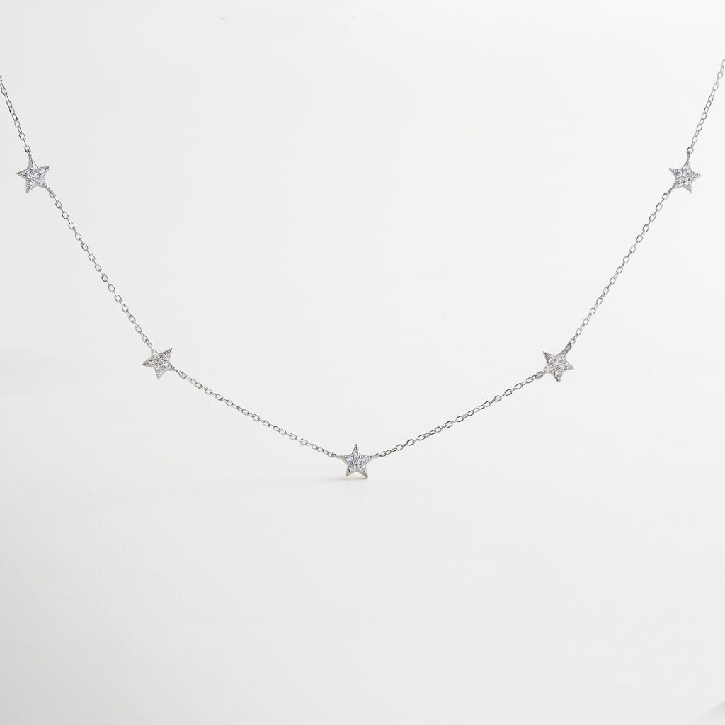 collar con dijes de estrellas pavé y cadena delgada, collar estrellado de plata con incrustaciones de zirconias, diseño celestial con charms de estrellas brillantes, collar inspirado en el cosmos con acabado en oro blanco, joya delicada con detalles de estrellas luminosas