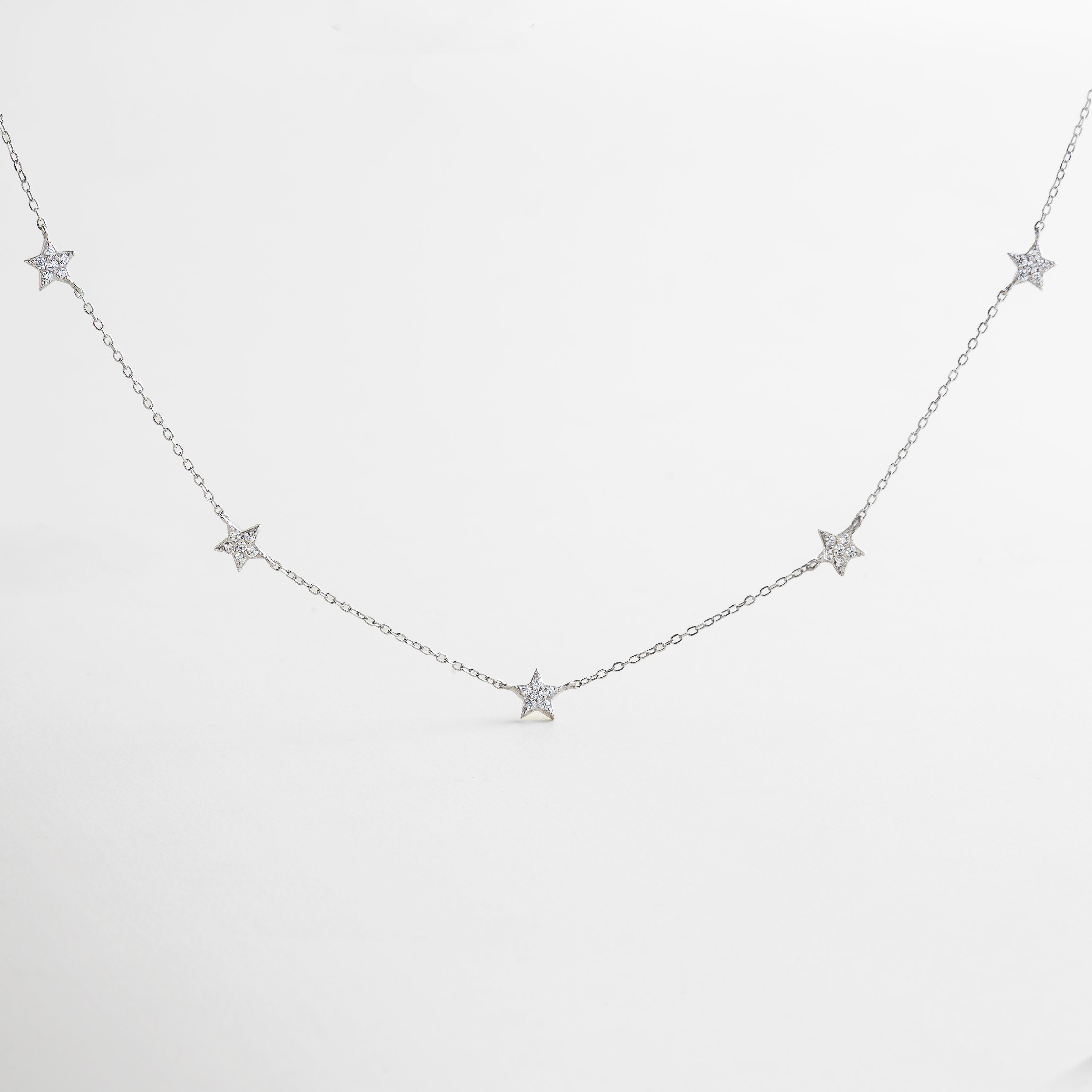 collar con dijes de estrellas pavé y cadena delgada, collar estrellado de plata con incrustaciones de zirconias, diseño celestial con charms de estrellas brillantes, collar inspirado en el cosmos con acabado en oro blanco, joya delicada con detalles de estrellas luminosas