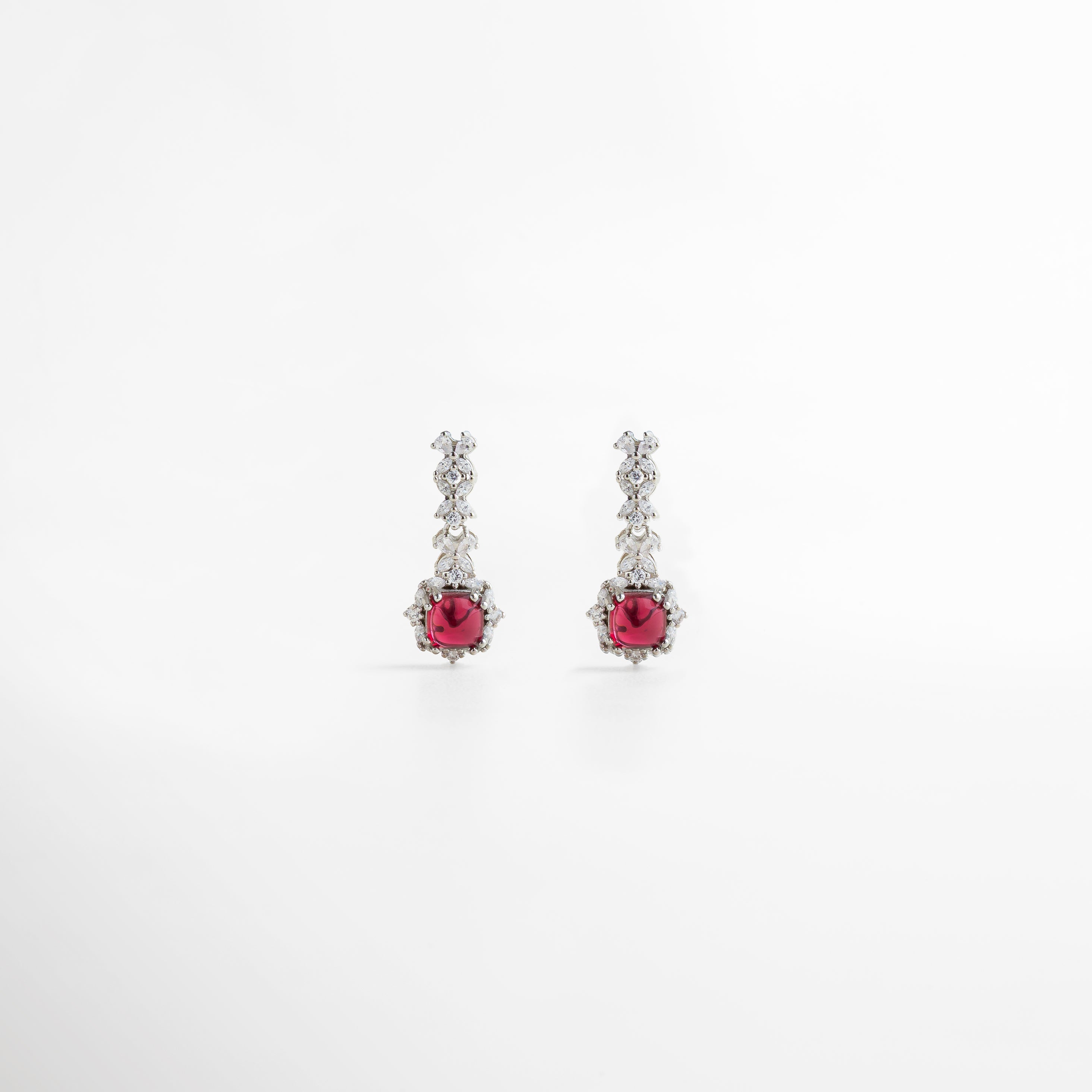 aretes plateados elegantes con piedra rubí cuadrada, diseño sofisticado y ornamental, joyería de lujo para ocasiones especiales, aretes largos que estilizan el rostro, accesorio ideal para elevar cualquier look