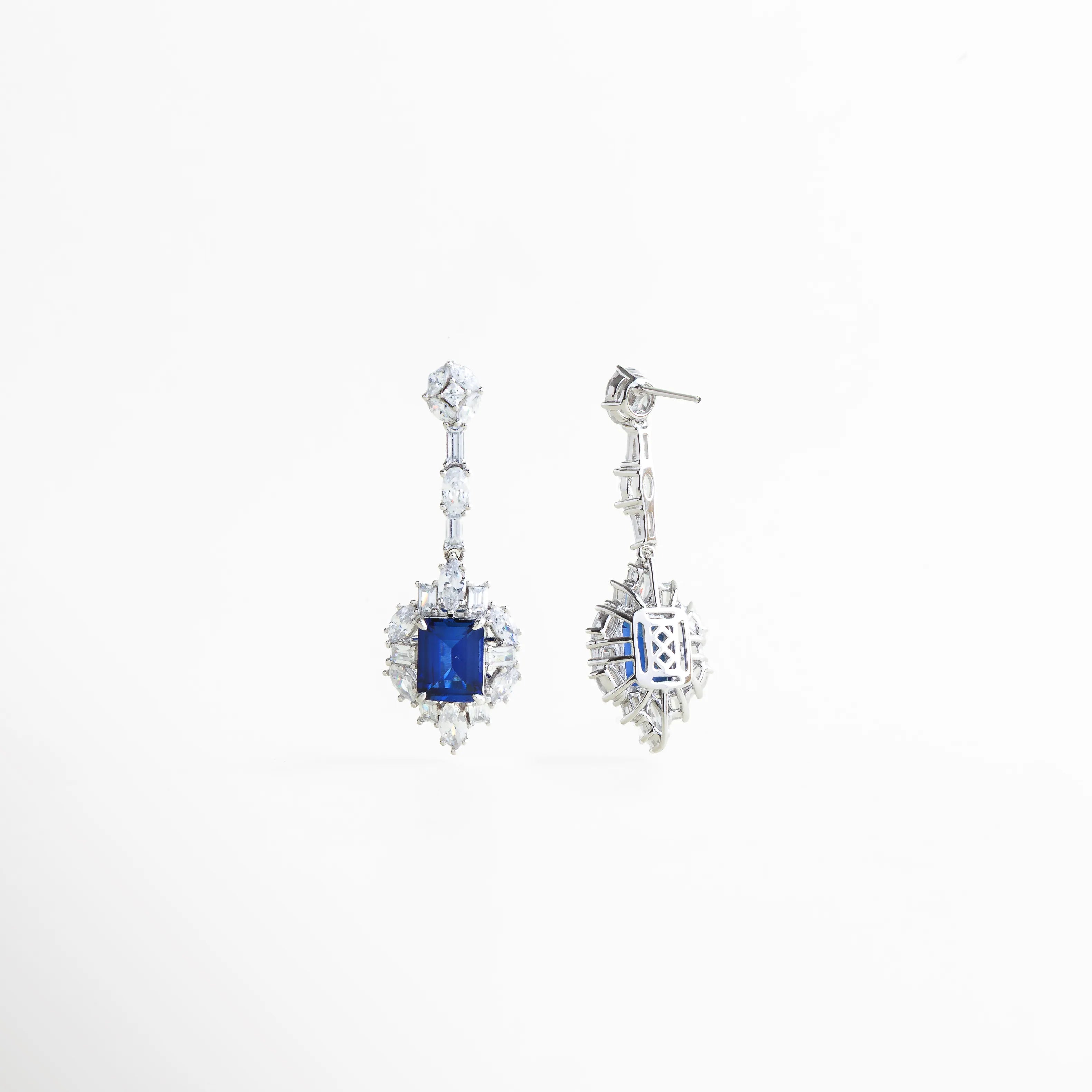 Parte posterior de los aretes Cordelia Azules con sello de autenticidad Plata Ley 925, Detalle del reverso de los pendientes de gala, mostrando el acabado pulido espejo, Vista técnica del cierre de mariposa y la estructura trasera de los aretes azules, Reverso de aretes con piedras cultivadas, resaltando la limpieza del diseño y el montaje, Vista de la calidad artesanal en la parte posterior de los pendientes Cordelia de plata.