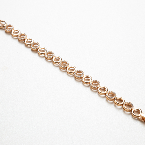 Detalle de pulsera Aro con cristales que reflejan la luz, combinación de aros dorados en movimiento, joyería delicada y refinada que aporta brillo sutil a cualquier outfit