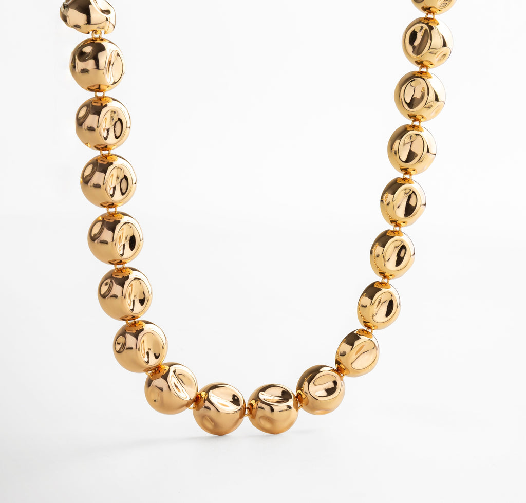 Collar dorado con dijes circulares unidos en cadena continua, diseño elegante y moderno que aporta movimiento y sofisticación, accesorio versátil para looks casuales o formales