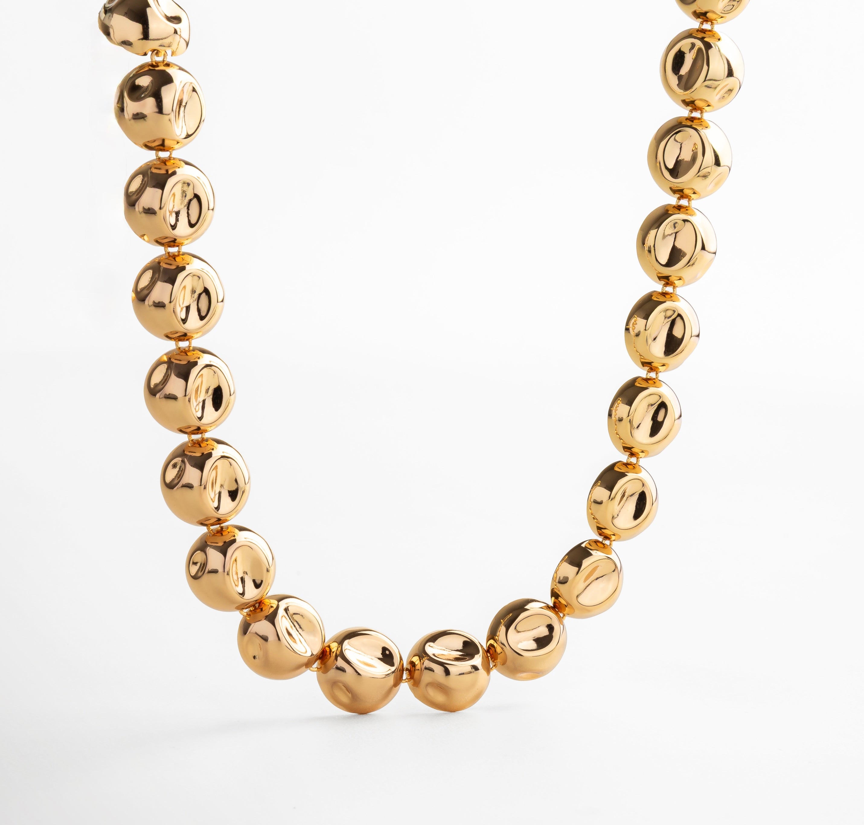 Collar dorado con dijes circulares unidos en cadena continua, diseño elegante y moderno que aporta movimiento y sofisticación, accesorio versátil para looks casuales o formales