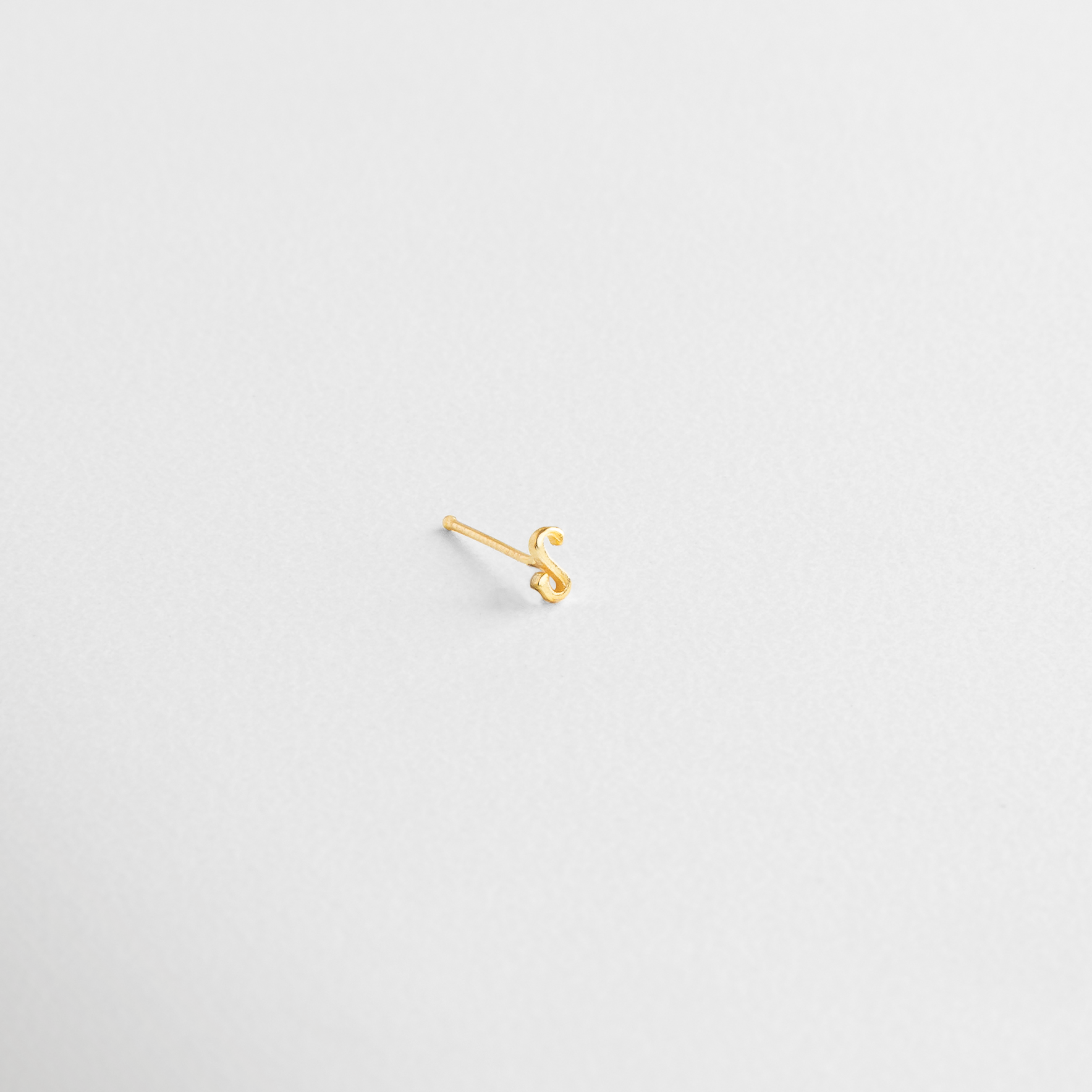 Piercing de inicial en oro brillante, Arete dorado con forma de letra pequeña, Joyería personalizada con letra dorada, Letra dorada en diseño minimalista, Piercing individual de inicial