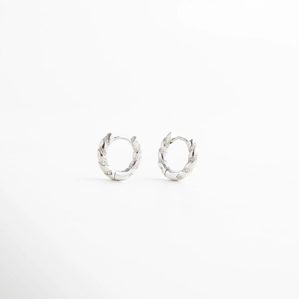 Aretes de aro plateados pequeños con diseño trenzado, estilo moderno y elegante, Arracadas plateadas con textura entrelazada, joyería minimalista y sofisticada.