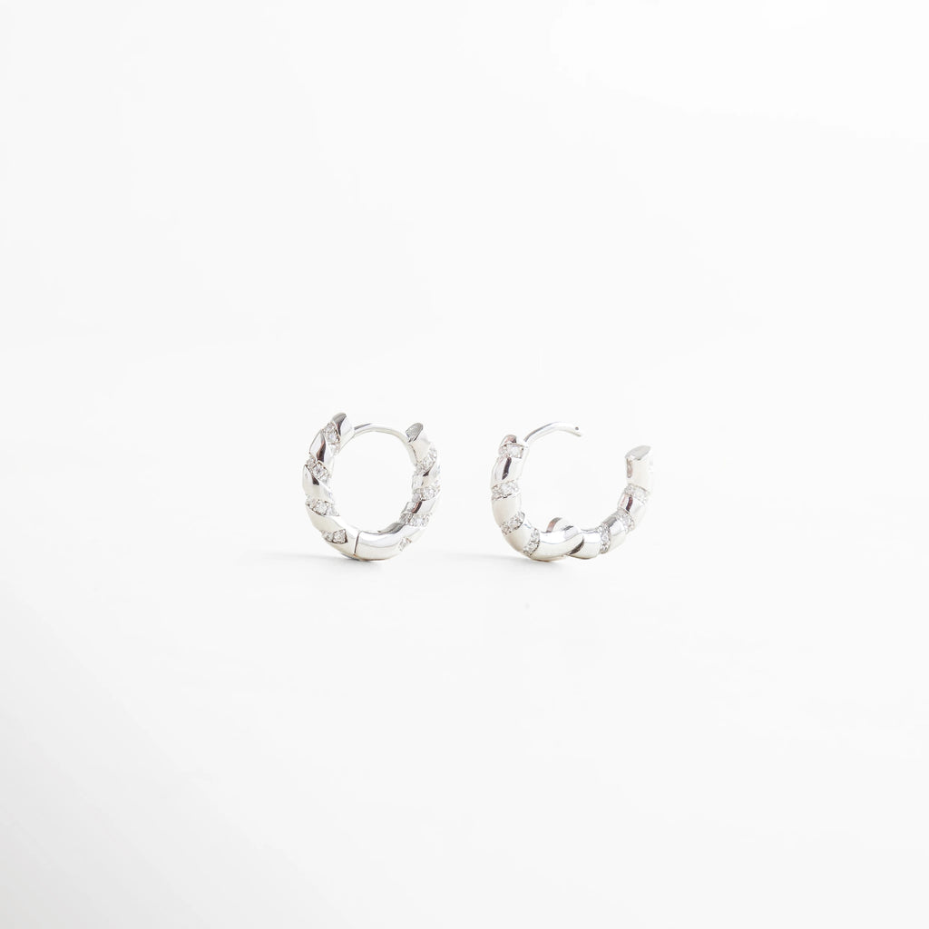 Aretes plateados de aro con diseño trenzado, detalle frontal y lateral, Arracadas plateadas entrelazadas, diseño versátil y moderno para uso diario.