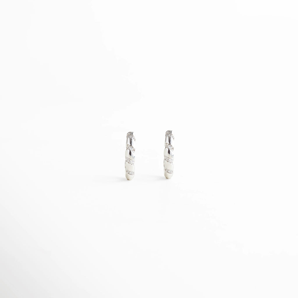 Aros plateados pequeños con acabado trenzado, diseño clásico y elegante, Aretes plateados estilo trenza vistos de frente, accesorios atemporales y versátiles.