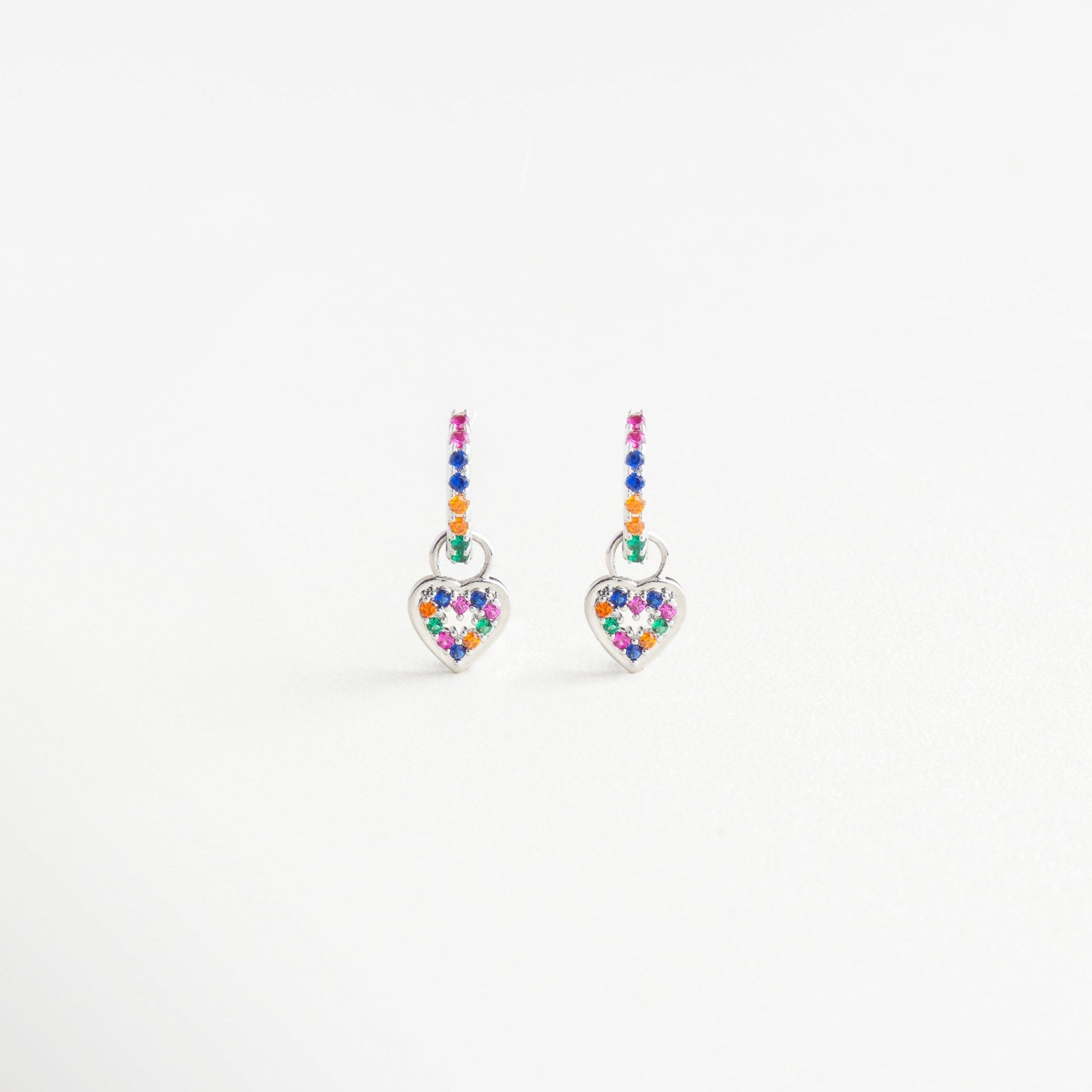 Aretes plateados con dije de corazón y zirconias multicolor, Par de arracadas plateadas con charm en forma de corazón, Aretes en tono plata con colgante vibrante de colores, Pendientes brillantes con corazón multicolor
