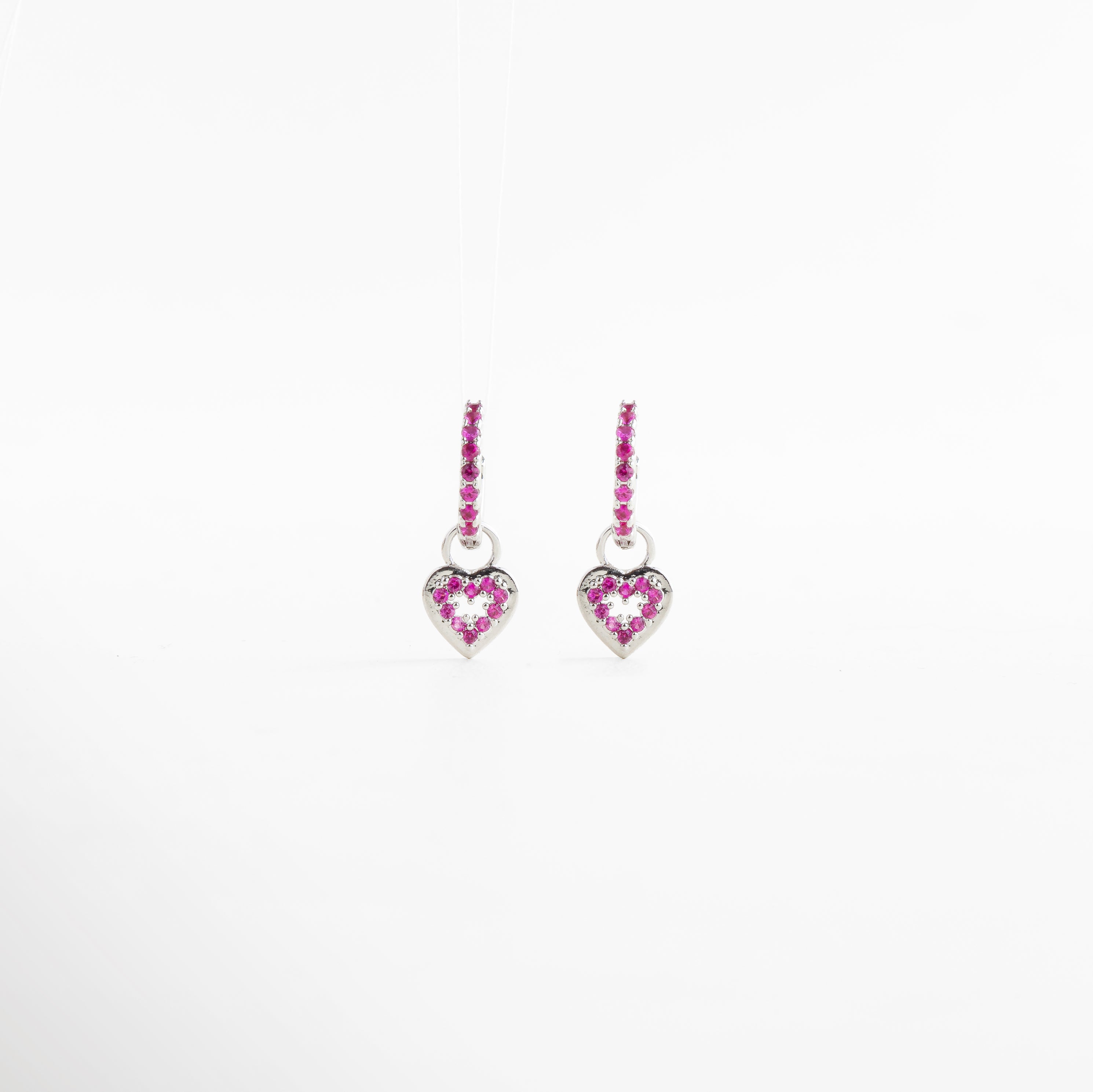 Arracadas pequeñas plateadas con dije de corazón, Aretes con zirconias rosas y forma colgante, Diseño delicado y femenino con acabado brillante, Argollas finas con charm en forma de corazón