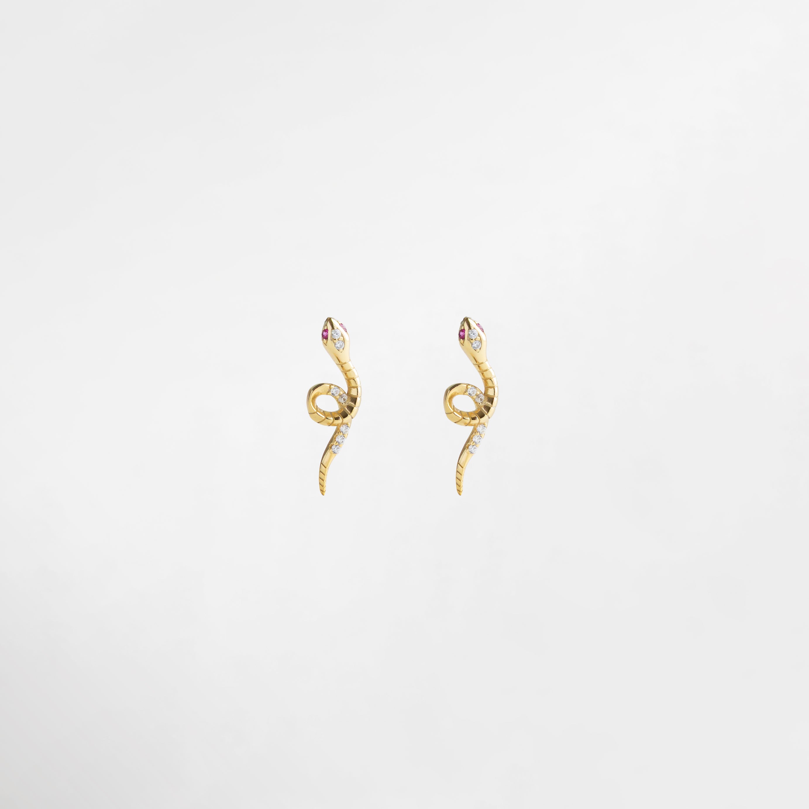 aretes dorados en forma de serpiente, diseño pequeño y lleno de carácter, incrustaciones de zirconias que aportan brillo sutil, joyería elegante para ocasiones especiales, accesorio femenino que transforma cualquier look
