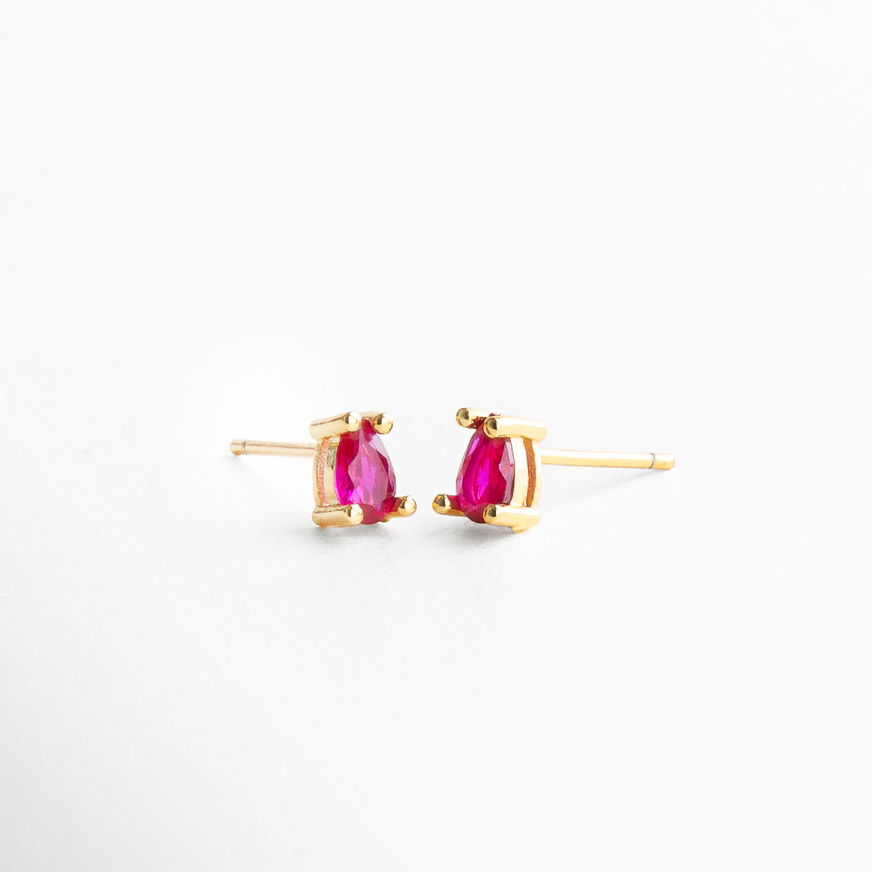 Aretes pequeños de 0.6 x 0.2 cm con piedra brillante, Proporción real de mini aretes dorados con zirconia, Studs dorados con zirconia en tamaño discreto, Medida visible de arete mini con diseño clásico