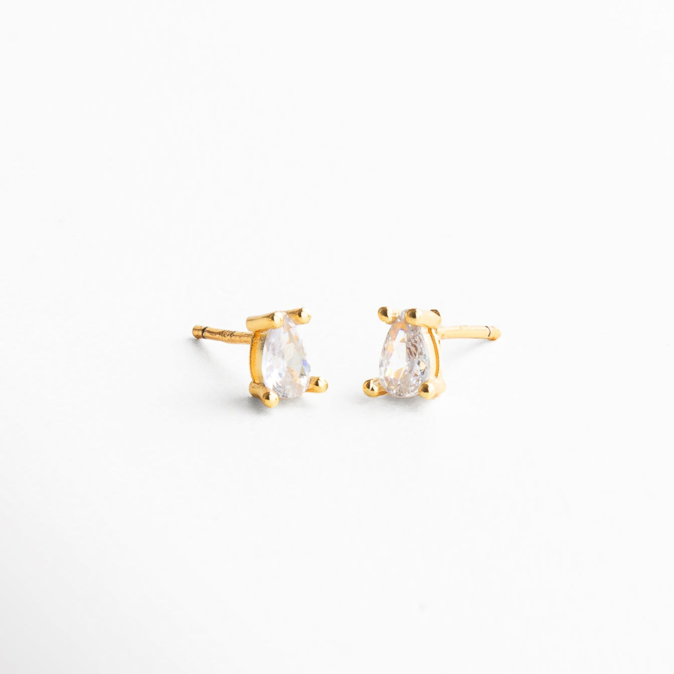 Arete mini stud dorado visto en ángulo, Perfil del arete pequeño con zirconia sutil, Vista en ángulo de zirconia engastada en base dorada, Stud delicado con diseño minimalista y elegante