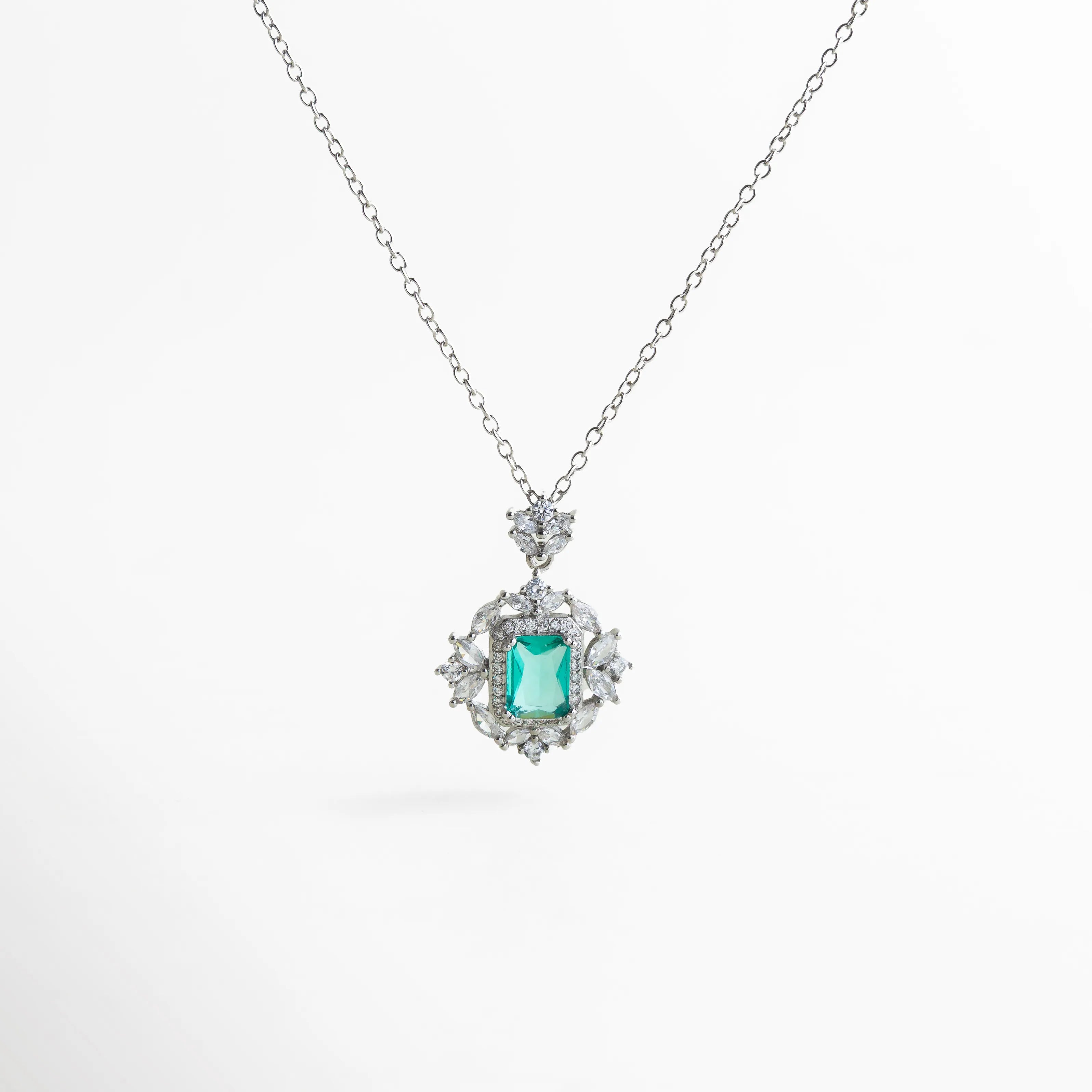 collar plateado con dije central verde esmeralda baguette rodeado de zirconias blancas en forma floral