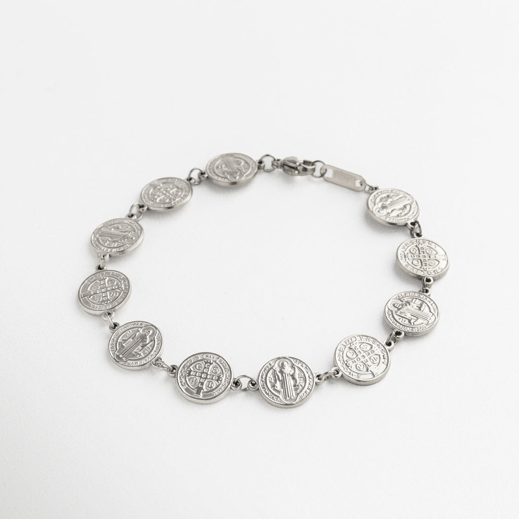 pulsera San Benito plateada con medallones, diseño elegante y simbólico, medallones unidos en cadena fina, acabado en oro blanco 18K, accesorio con significado y estilo