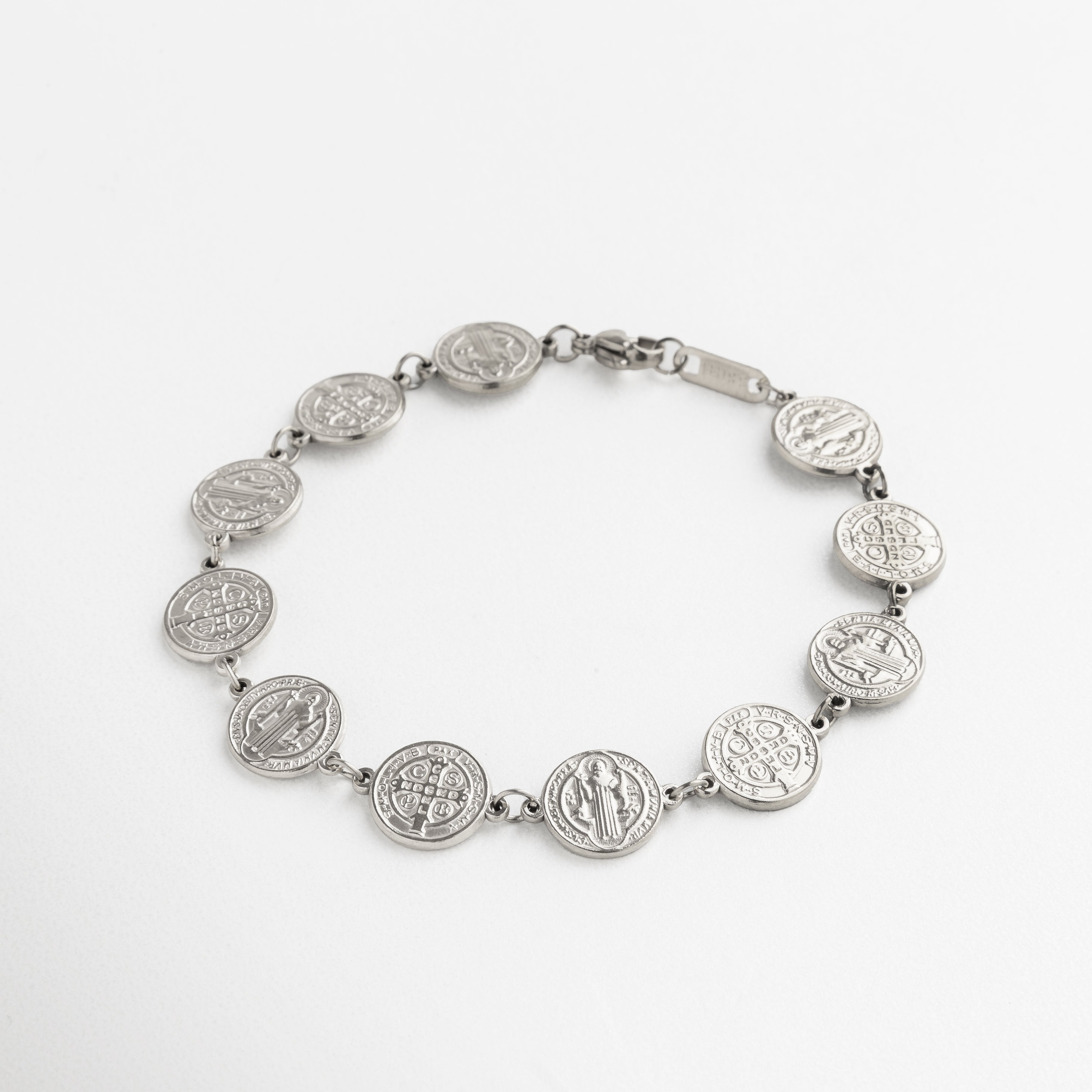 pulsera San Benito plateada con medallones, diseño elegante y simbólico, medallones unidos en cadena fina, acabado en oro blanco 18K, accesorio con significado y estilo