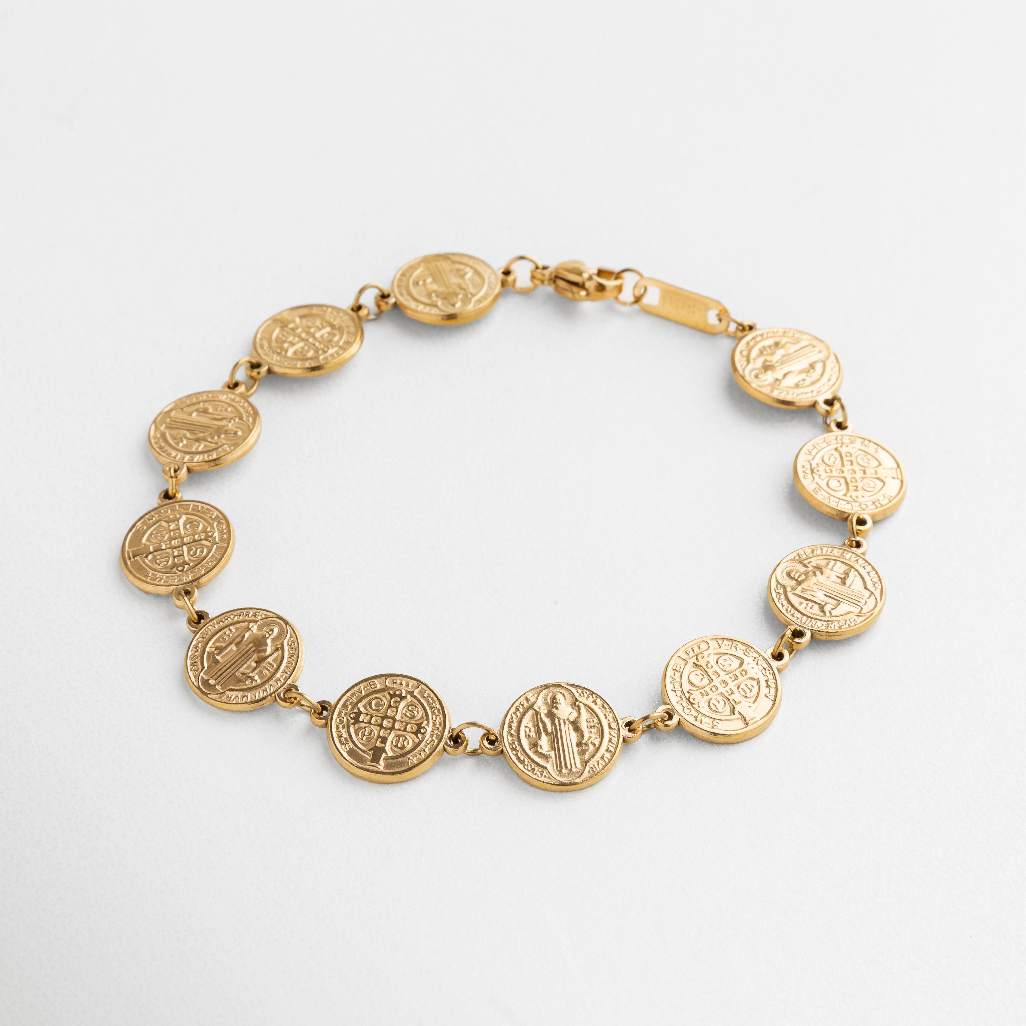 pulsera San Benito dorada con medallones, diseño elegante y simbólico, medallones unidos en cadena fina, acabado en oro 18K, accesorio con significado y estilo