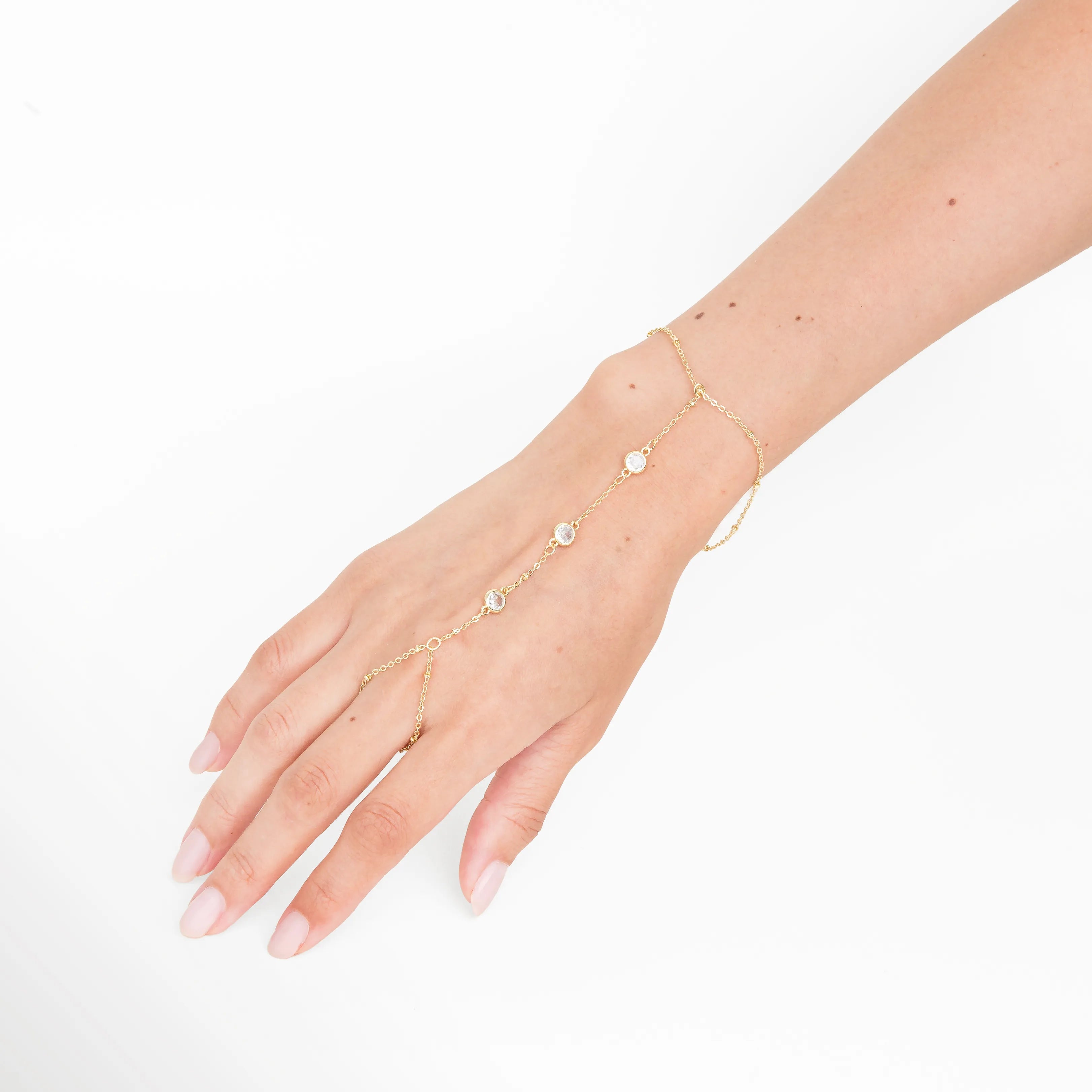 pulsera hand chain en uso, joyería dorada elegante, pulsera fina outfit, accesorios femeninos, pulsera delicada moderna, joyería sofisticada