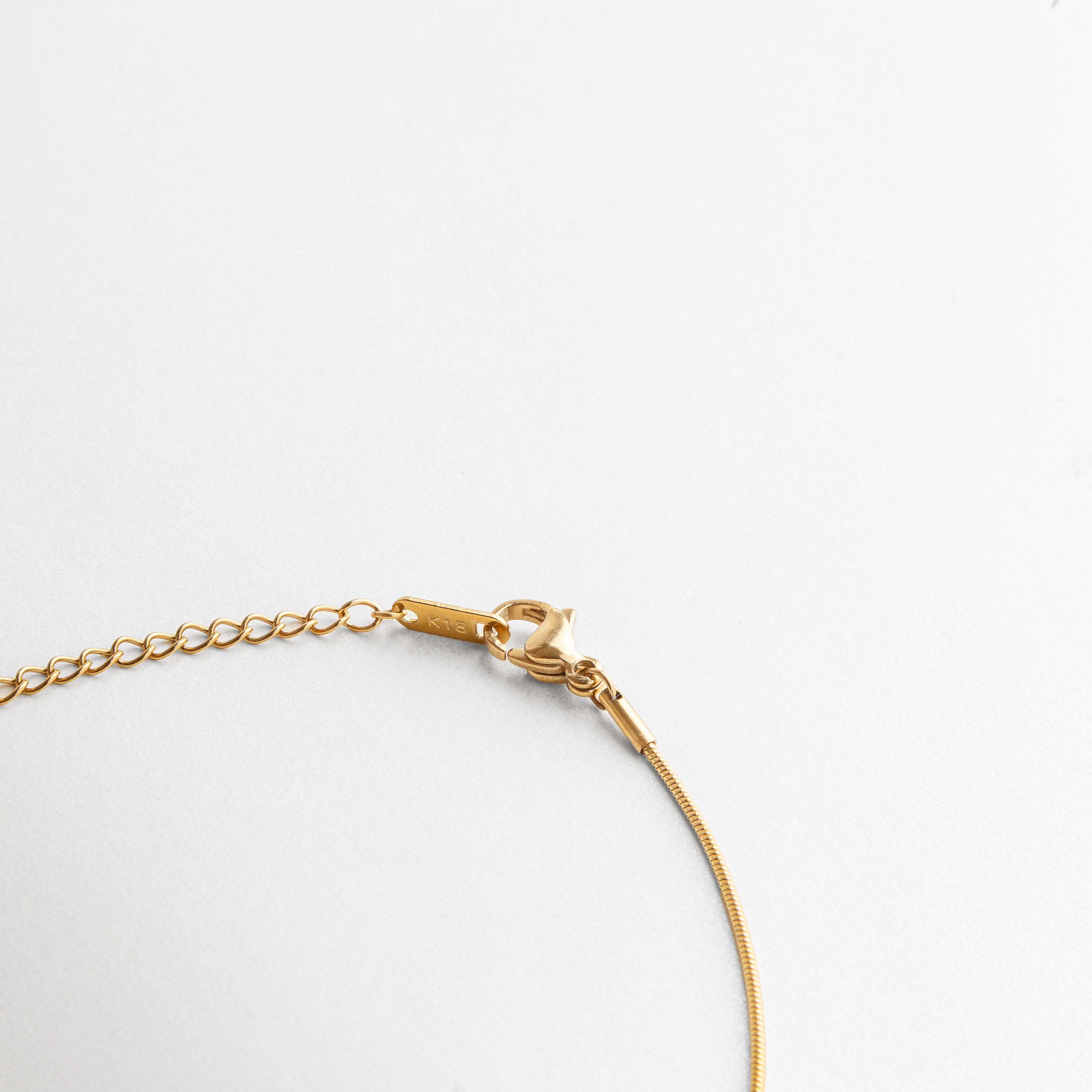 Cierre seguro tipo langosta en acero inoxidable con extensión ajustable, chapado en oro 18K, que permite adaptar el largo del collar para diferentes estilos y combinaciones