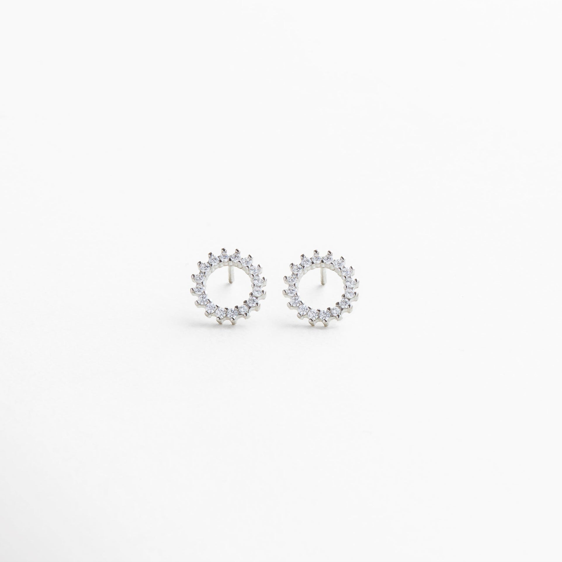 Aretes pequeños circulares plateados con zirconia cúbica incrustada, Diseño minimalista de arandela plateada con brillo sutil, Aretes discretos con acabado enchapado en oro blanco 18K, Joyería femenina elegante de tamaño mini con piedra brillante, Aretes plateados tipo stud para look atemporal y versátil
