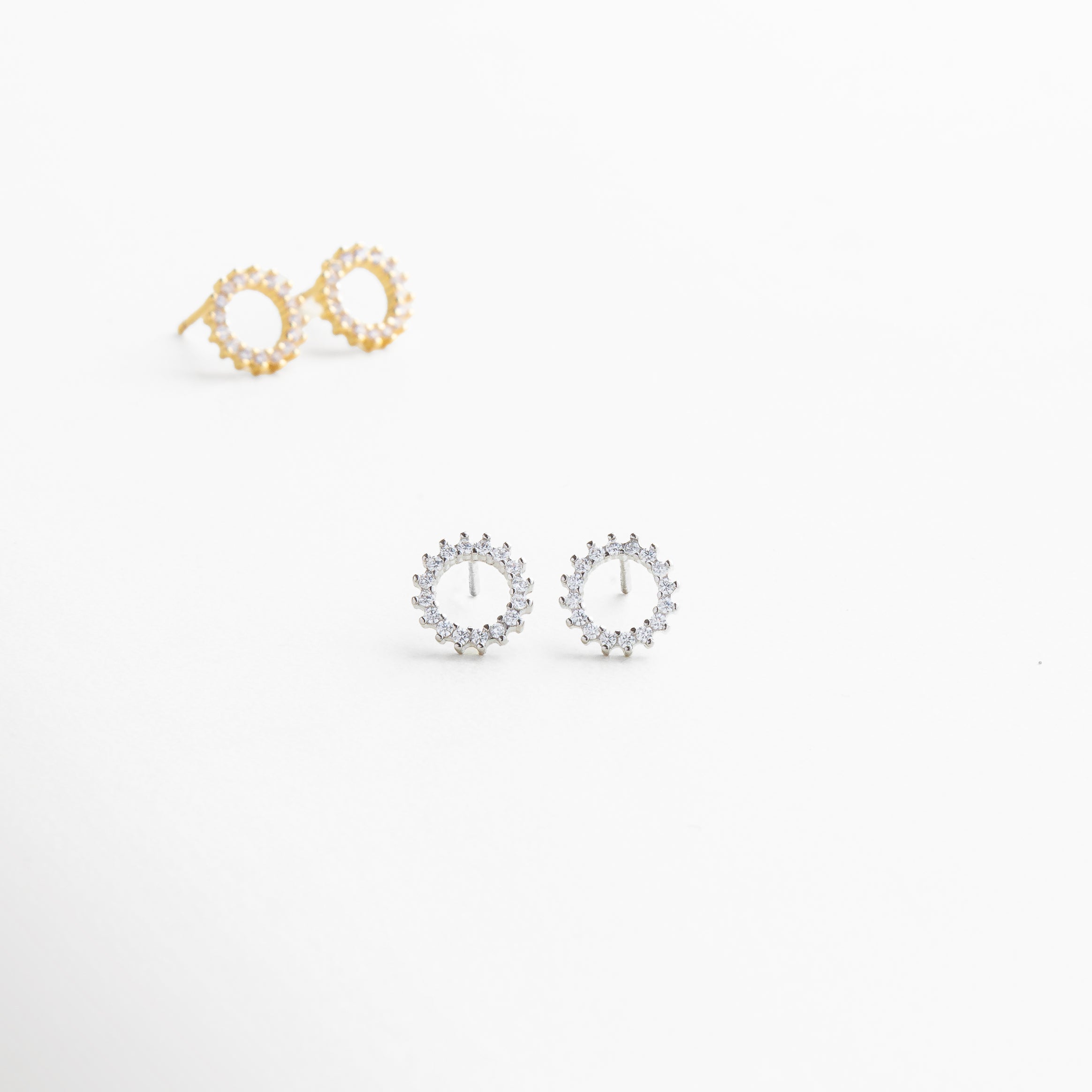 Primer plano de arandela plateada con zirconias incrustadas, Detalle de engaste preciso en aretes pequeños plateados, Textura pulida y brillante en mini aretes circulares, Zirconia cúbica brillante en diseño minimalista plateado, Acabado uniforme en arandela plateada con borde pulido