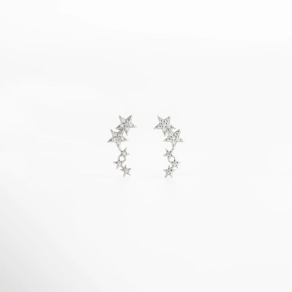 aretes estrellas vista completa, joyería plateada elegante, aretes delicados modernos, accesorios femeninos plateados, aretes ligeros mujer, joyería minimal con estrellas, aretes chic plateados, joyería sutil mujer