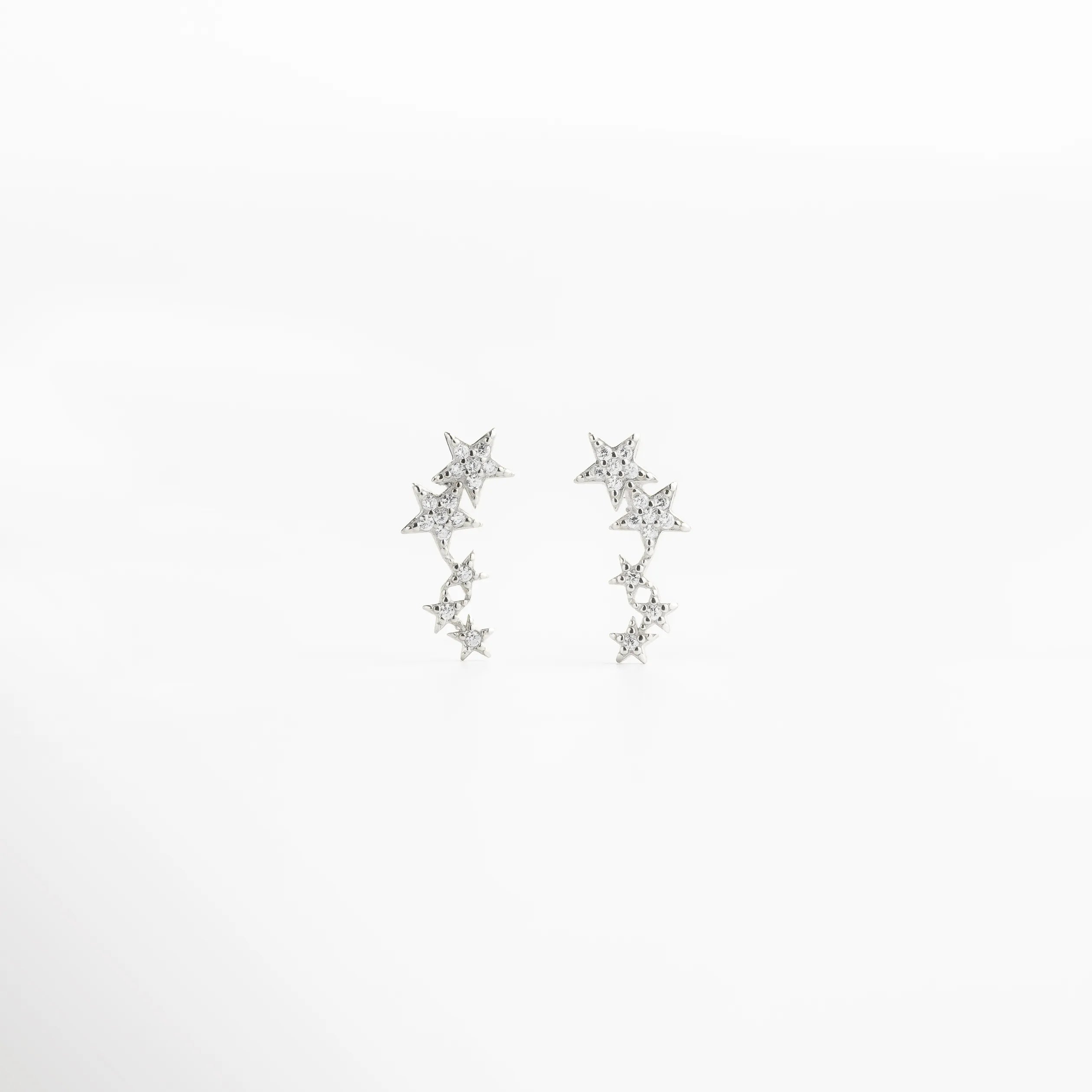 aretes estrellas vista completa, joyería plateada elegante, aretes delicados modernos, accesorios femeninos plateados, aretes ligeros mujer, joyería minimal con estrellas, aretes chic plateados, joyería sutil mujer